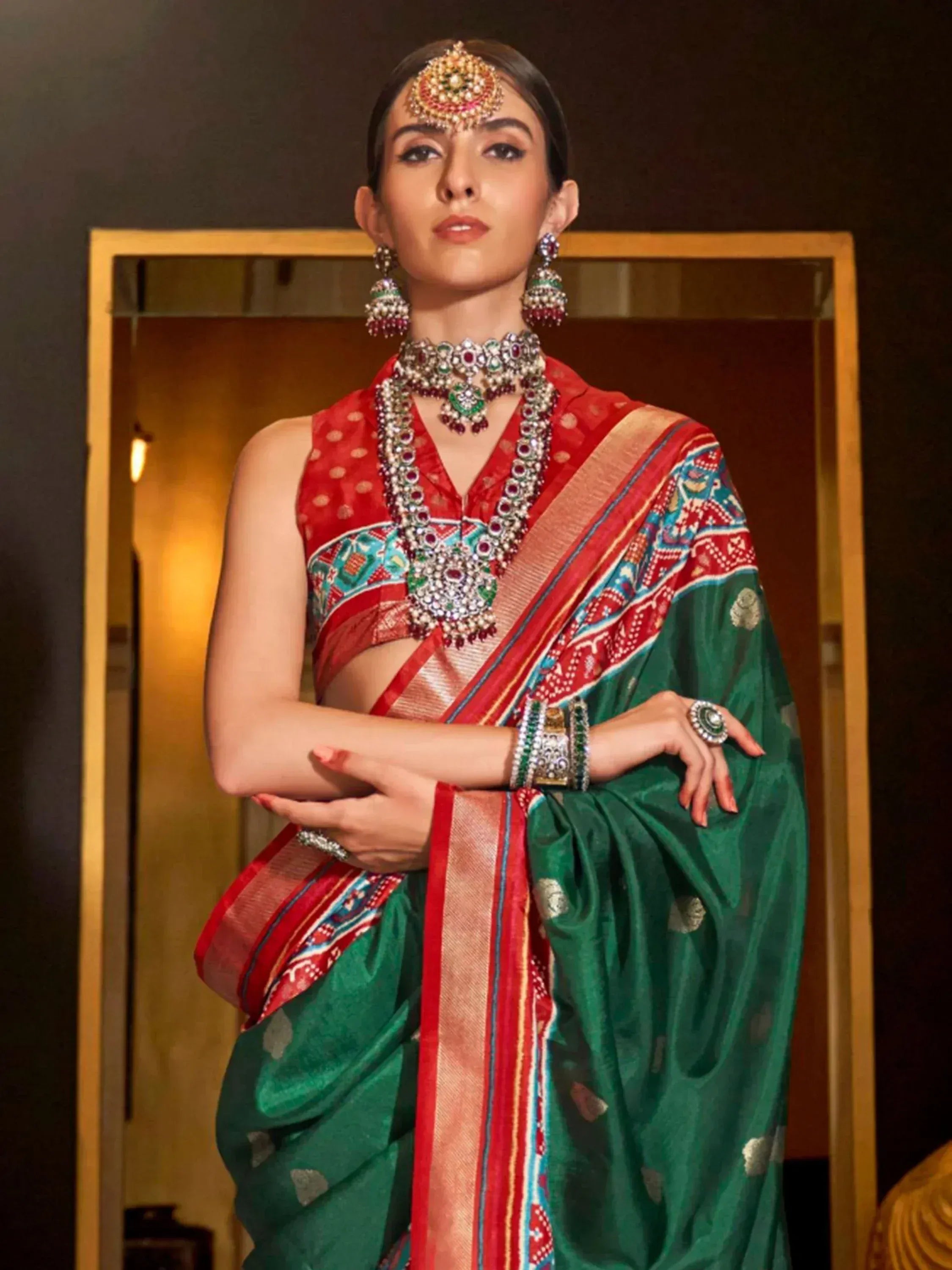 Woman in green and red ethnic saree with traditional jewelry, perfect for Indian festive occasions