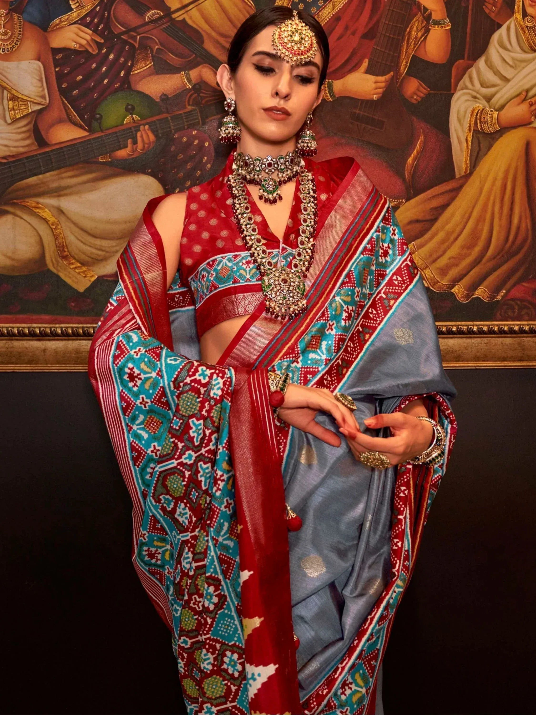 Woman in red and blue patterned saree with heavy jewelry, Indian ethnic wear