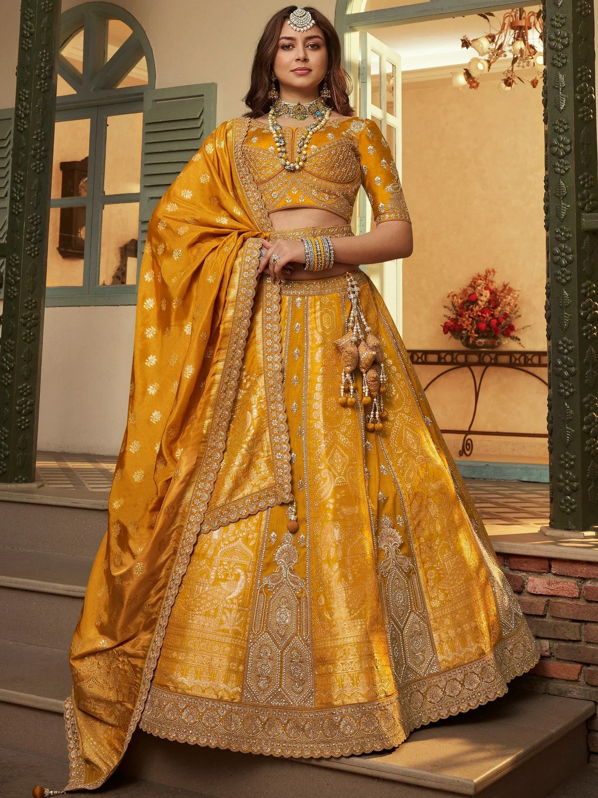 Golden designer lehenga choli with intricate embroidery and embellishments, perfect for weddings and festive occasions.