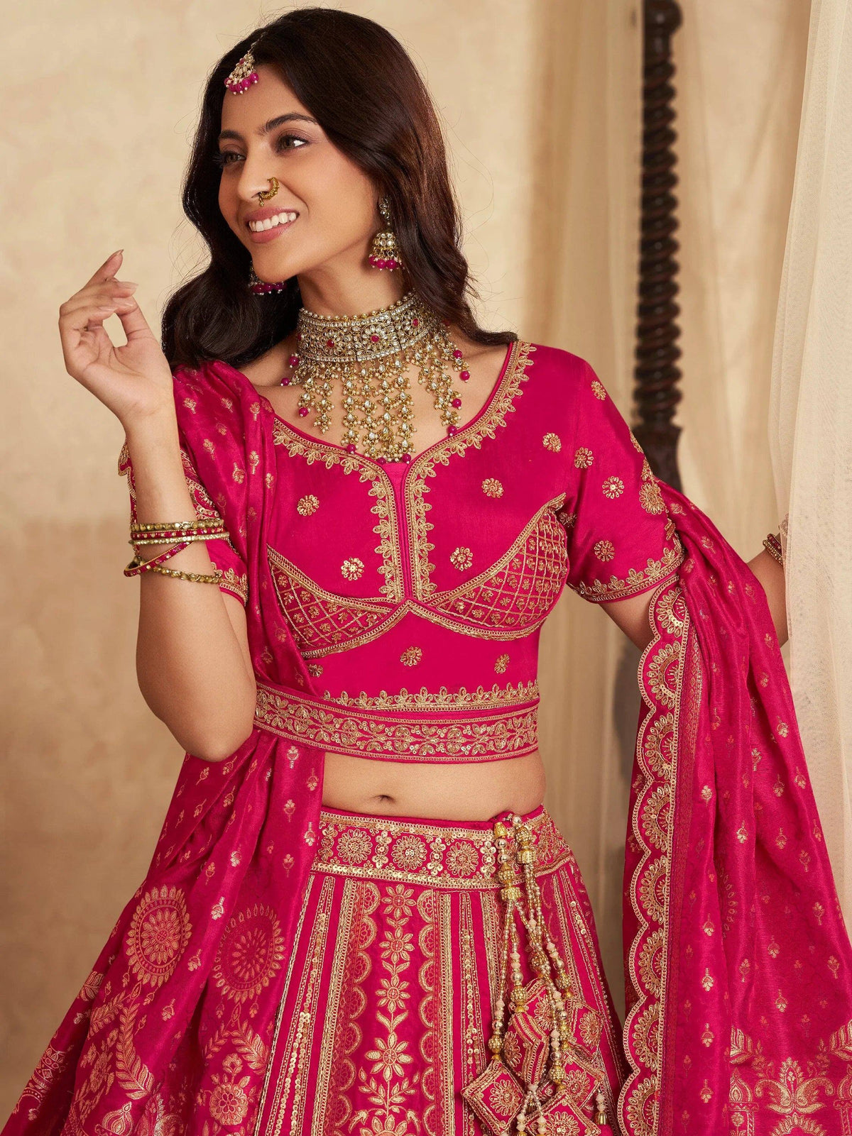 Pink designer lehenga choli with gold embroidery, perfect for Indian weddings and festive occasions.
