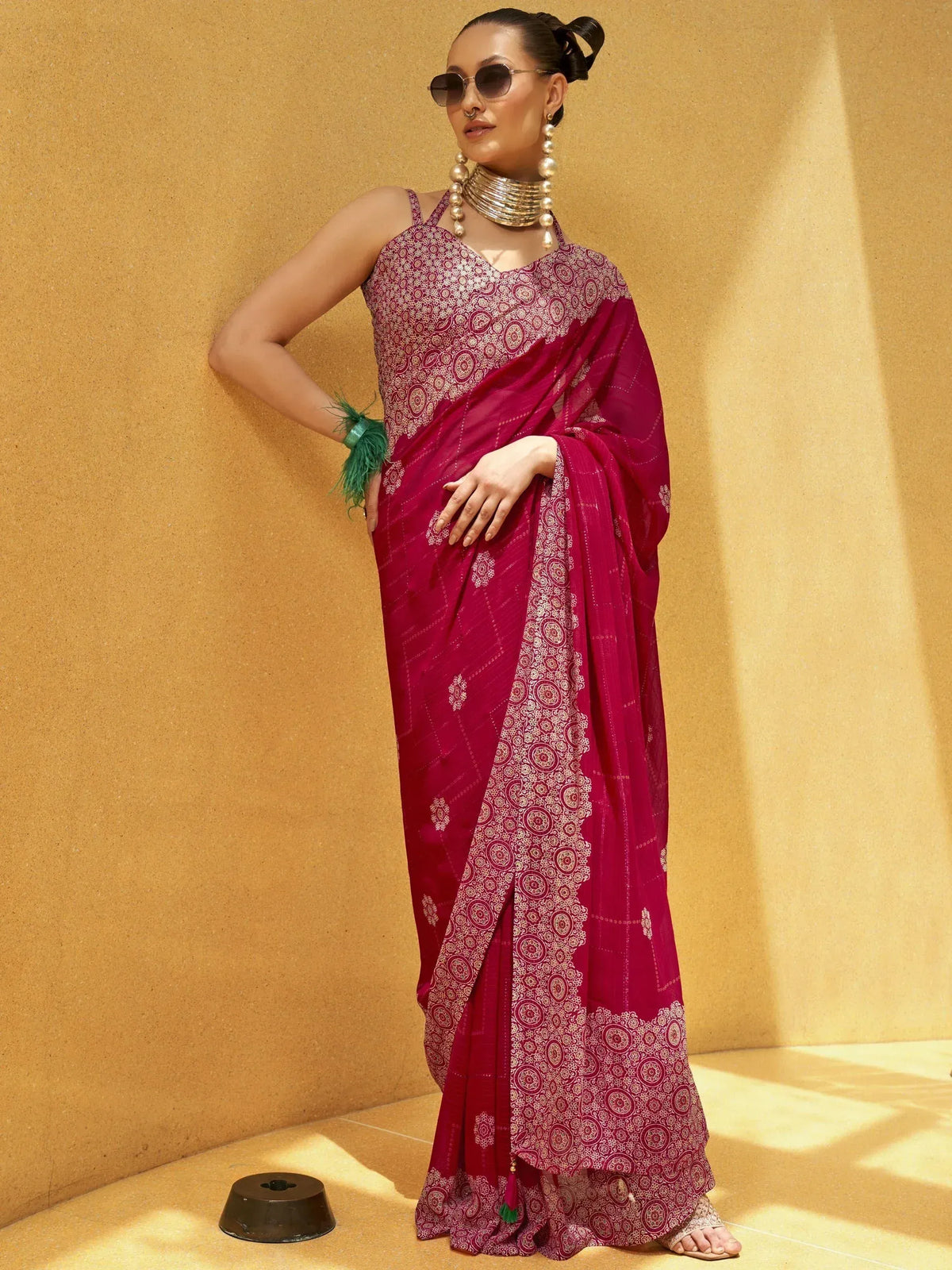 Woman in maroon printed saree with gold jewelry, stylish ethnic wear for festive occasions