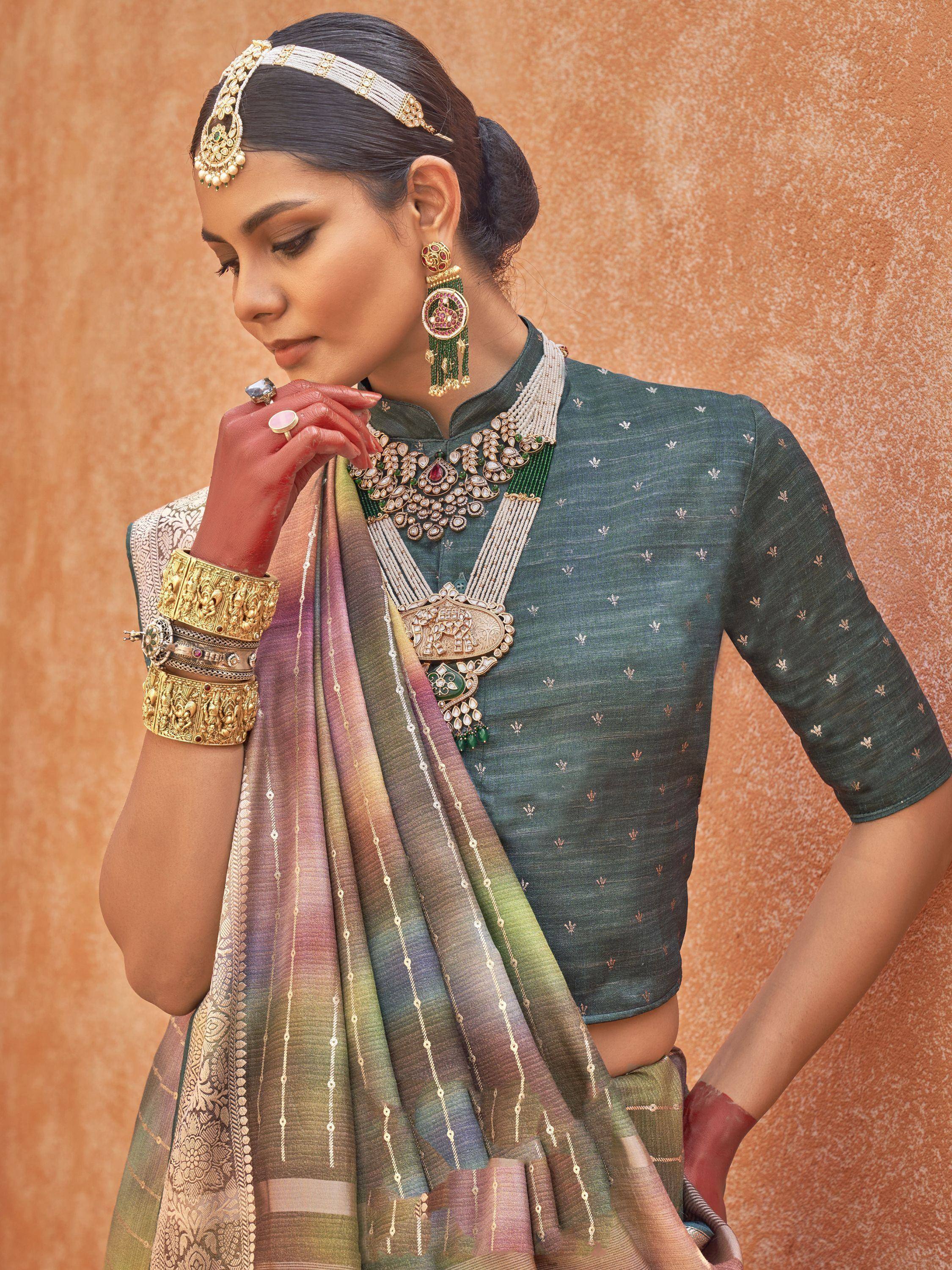 Woman in green embroidered blouse with colorful saree and traditional Indian jewelry