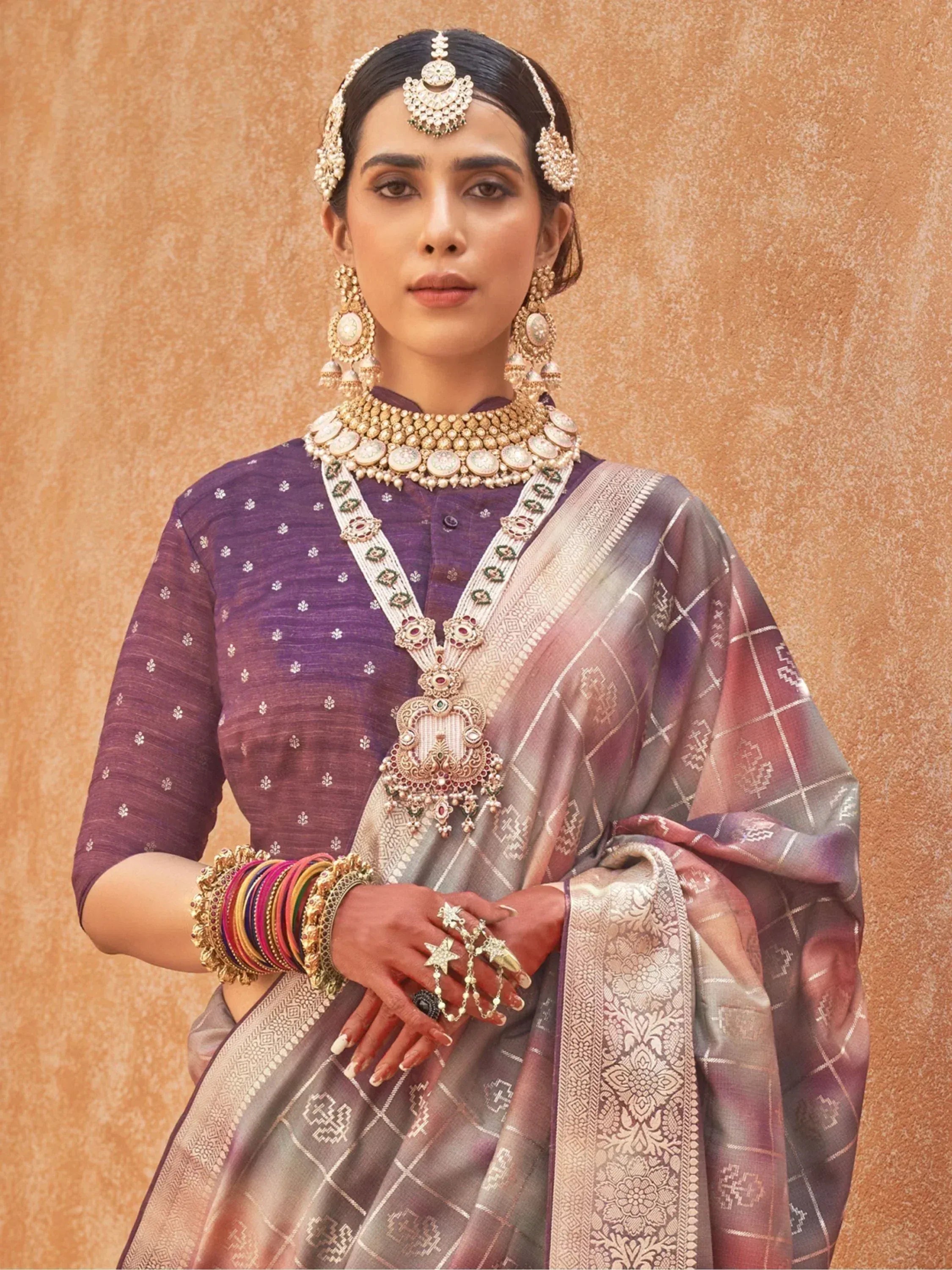 Elegant Indian woman in purple saree with gold embroidery, traditional jewelry, and floral blouse for festive occasions