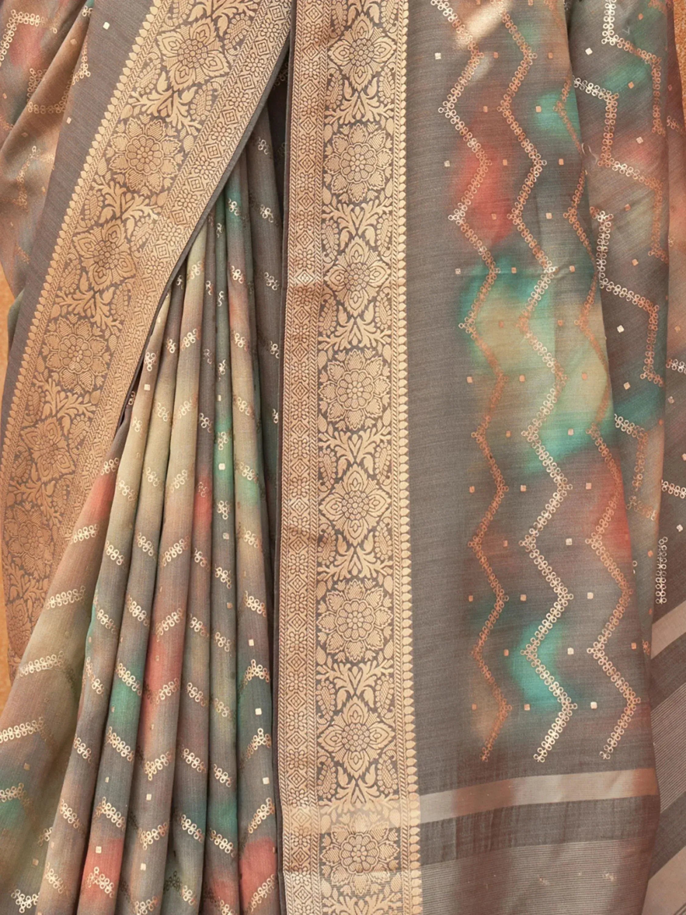 Elegant grey saree with gold floral border and geometric zari patterns, perfect for Indian ethnic wear.