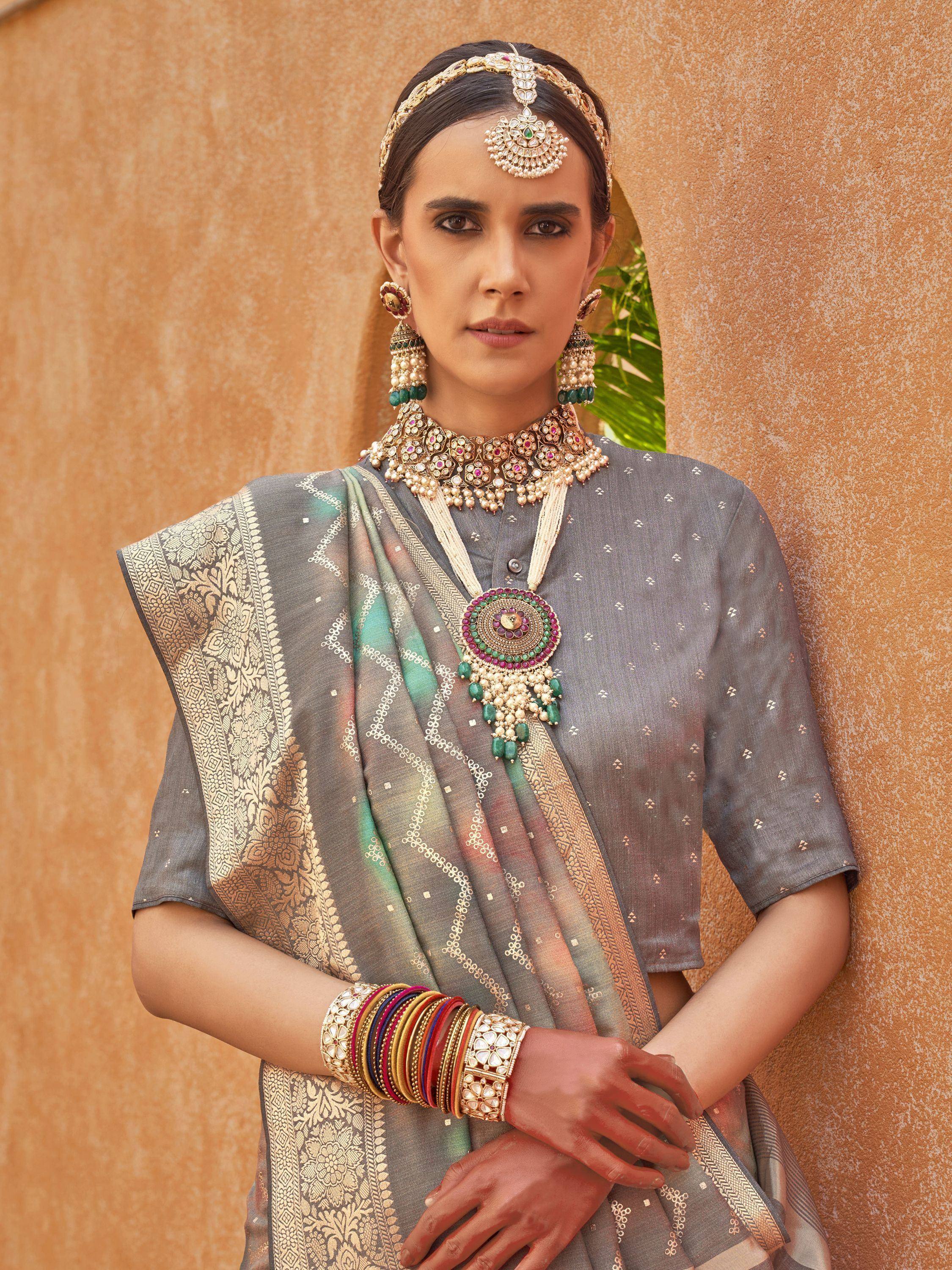 Grey ethnic saree with gold embroidery, traditional jewelry, and statement necklace for Indian occasions