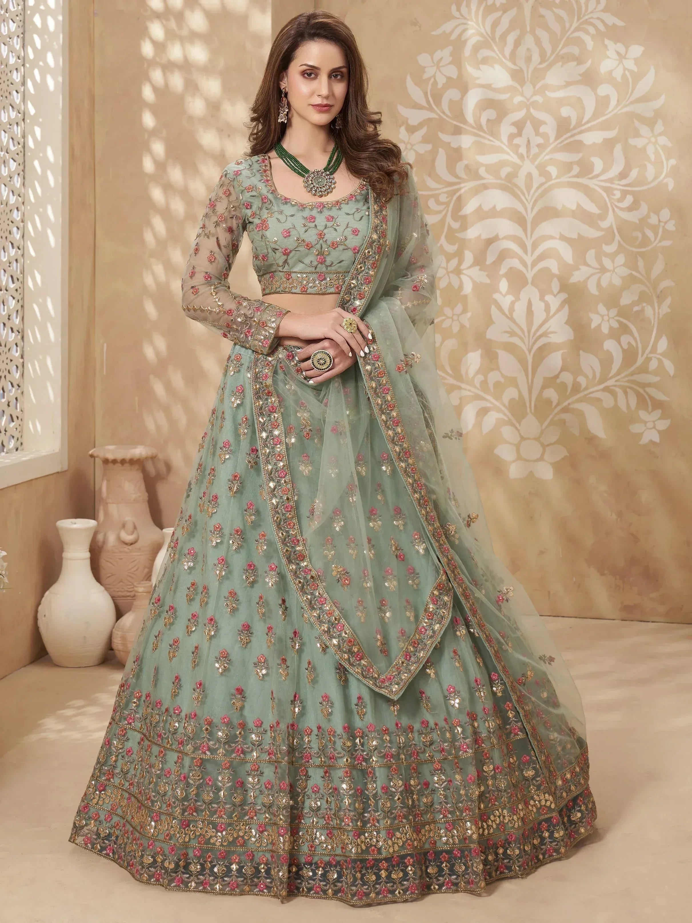 Mint green embroidered lehenga choli with floral motifs and gold detailing, perfect for Indian weddings or festive occasions.