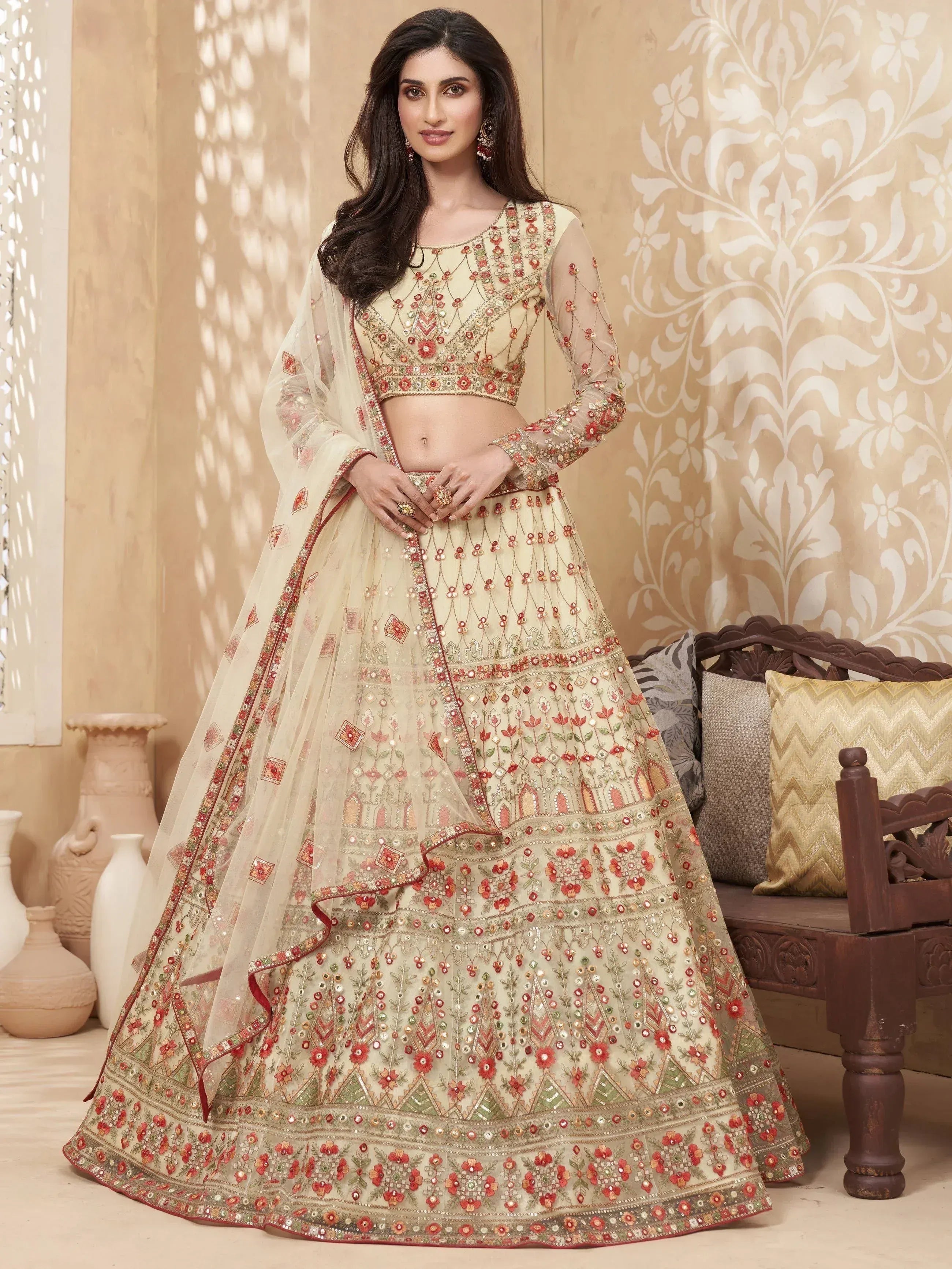 Elegant cream lehenga choli with red floral embroidery and sheer dupatta, perfect for Indian weddings and festive occasions.