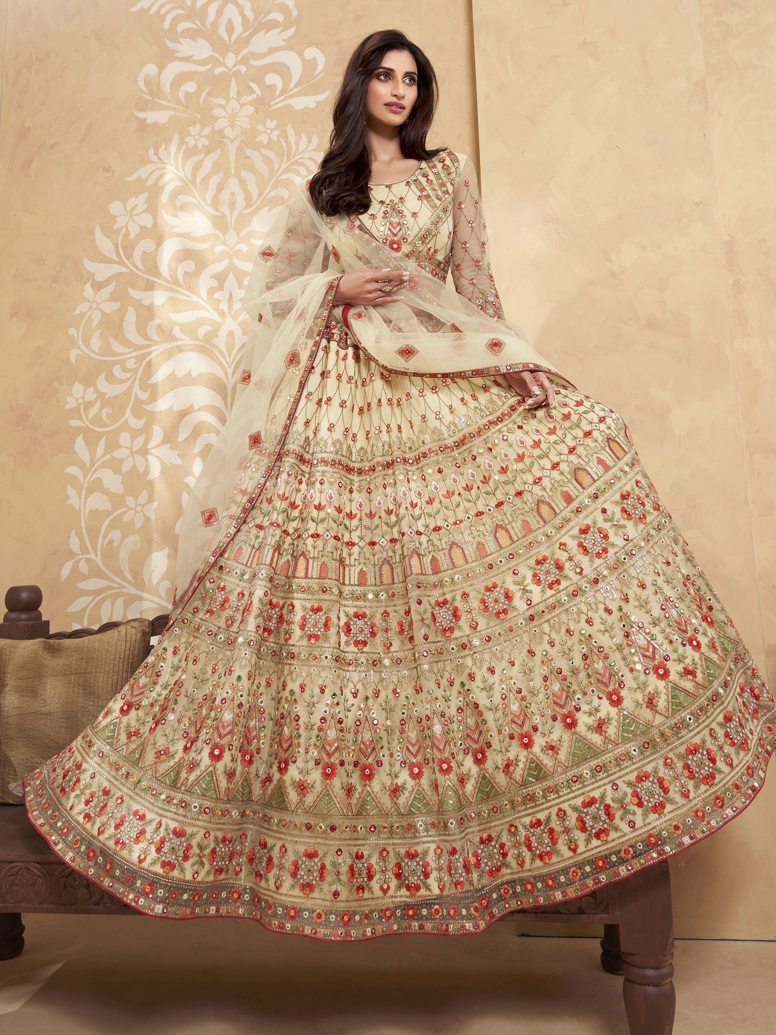 Elegant cream lehenga choli with red floral embroidery and mirror work, perfect for Indian weddings and festive occasions.