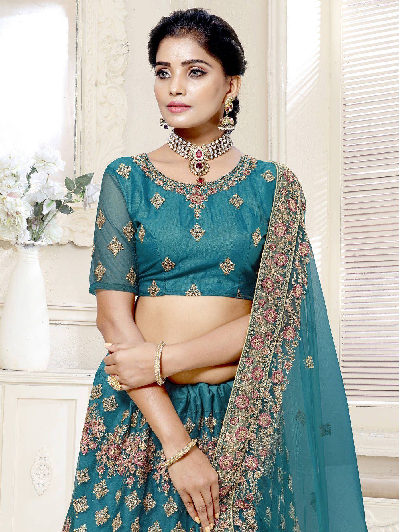Teal designer lehenga choli with gold and pink floral embroidery, perfect for Indian ethnic wear occasions.