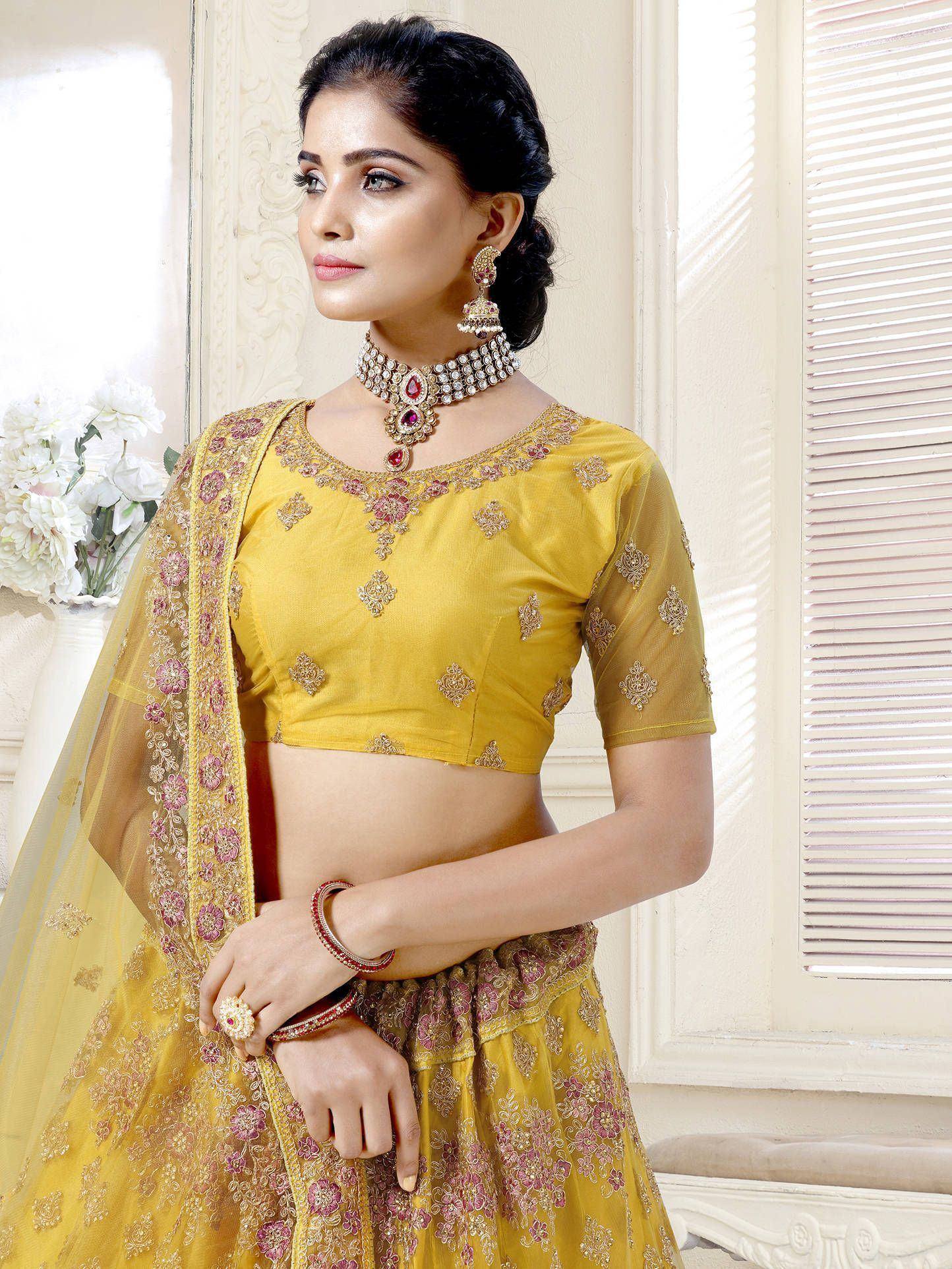 Yellow embroidered lehenga choli with floral motifs and matching dupatta, perfect for Indian ethnic occasions.