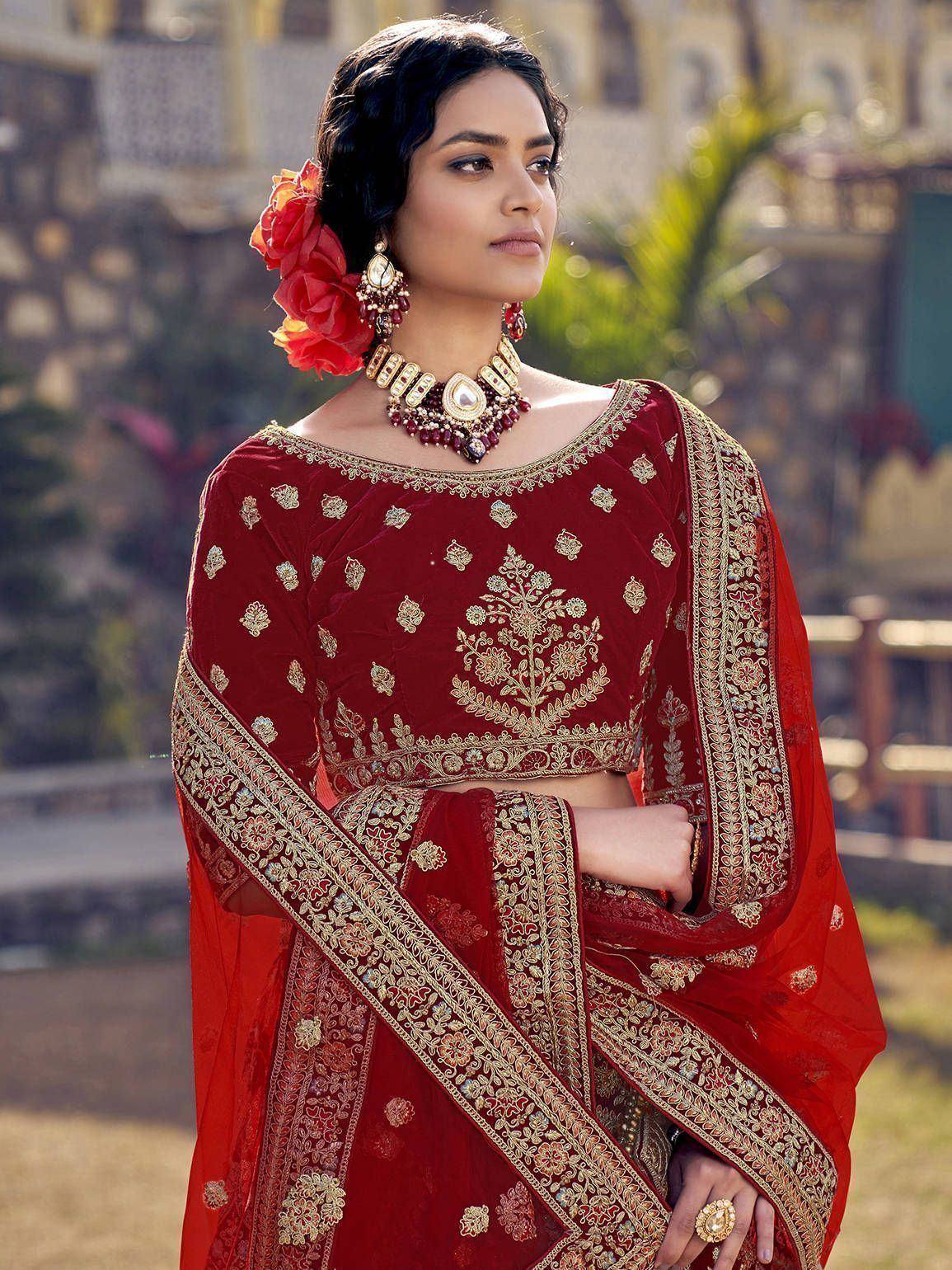 Red velvet embroidered lehenga choli with gold detailing, perfect for Indian weddings and festive occasions.