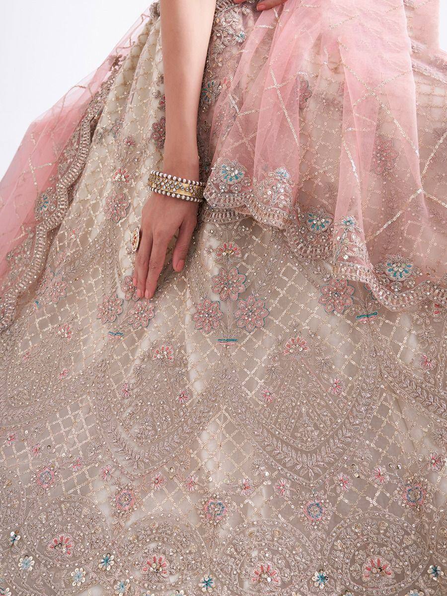 Elegant pink and beige embroidered lehenga with floral motifs and sequin detailing, perfect for Indian weddings.