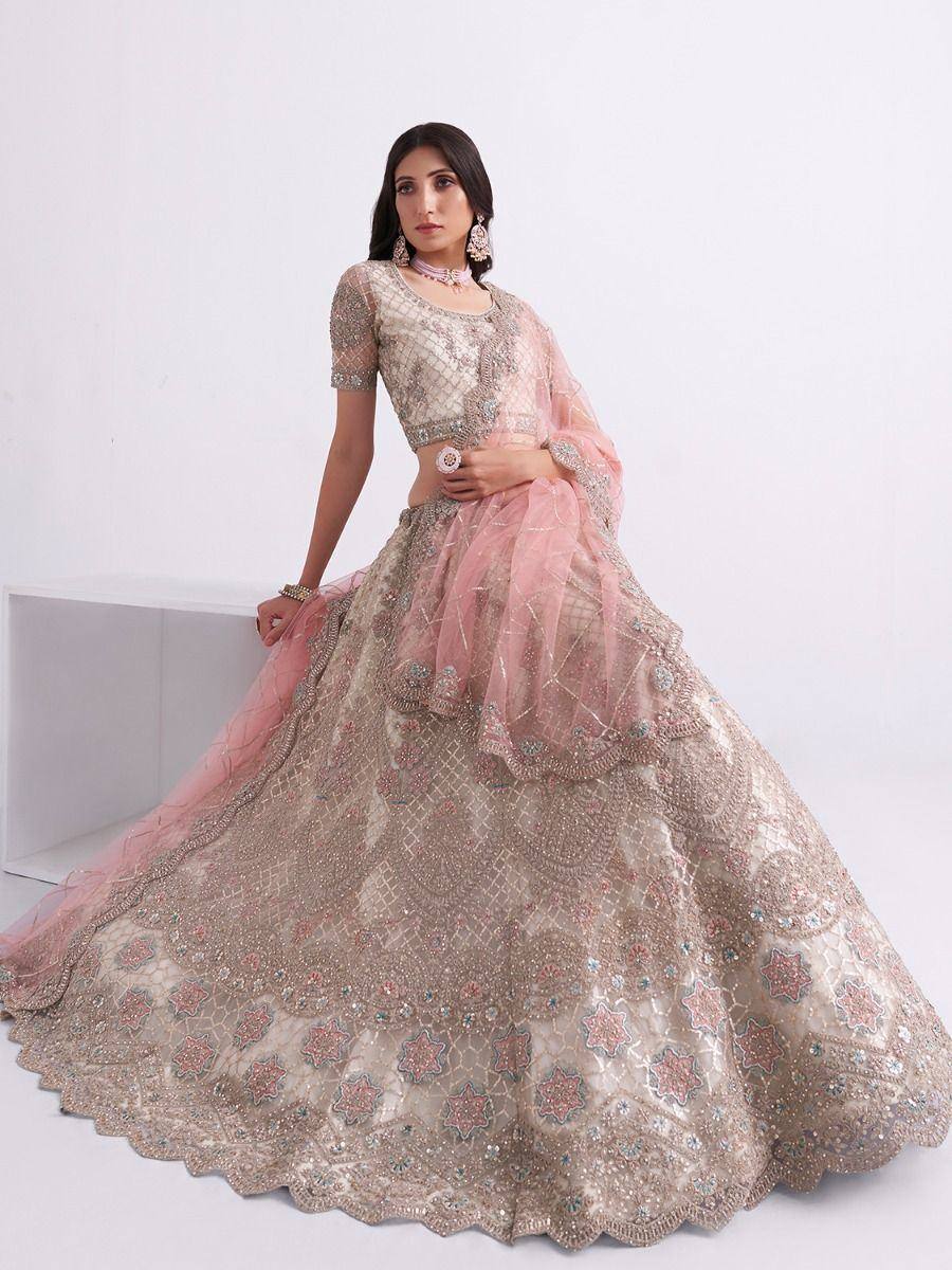 Elegant pink and gold embroidered lehenga choli with sheer dupatta, perfect for Indian weddings and festive occasions.