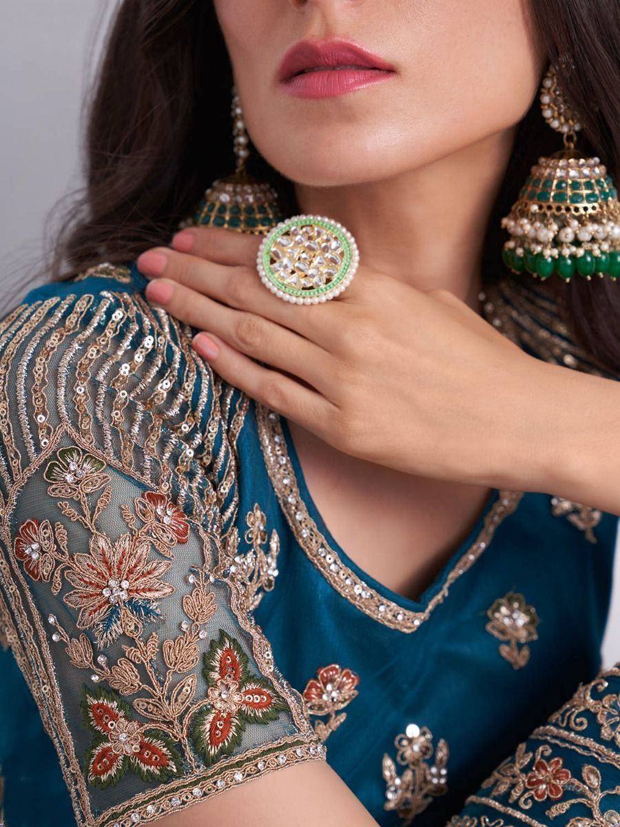 Teal embroidered ethnic blouse with floral detailing, paired with statement jhumka earrings and ring