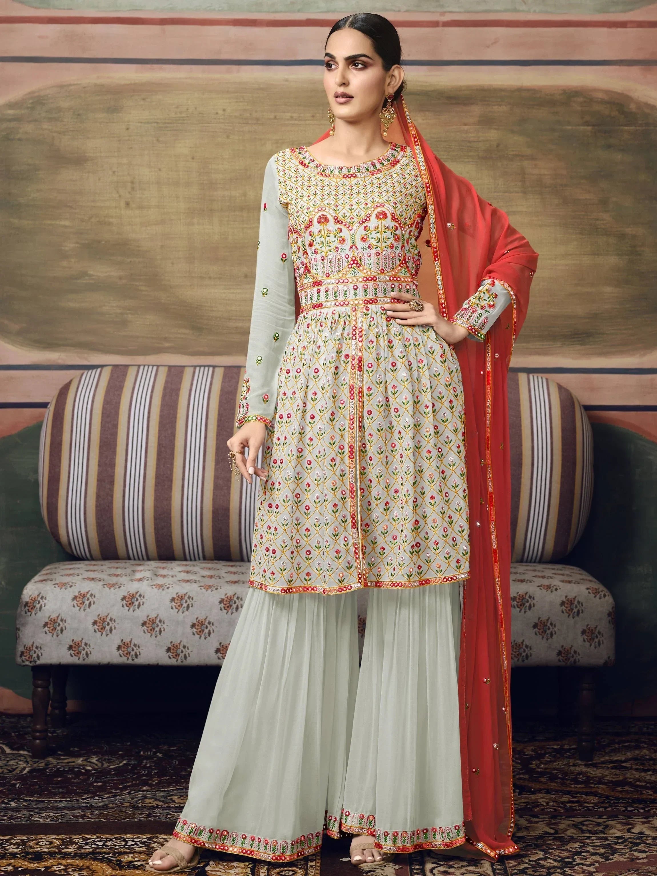 Woman in embroidered pastel sharara suit with red dupatta, Indian ethnic wear fashion