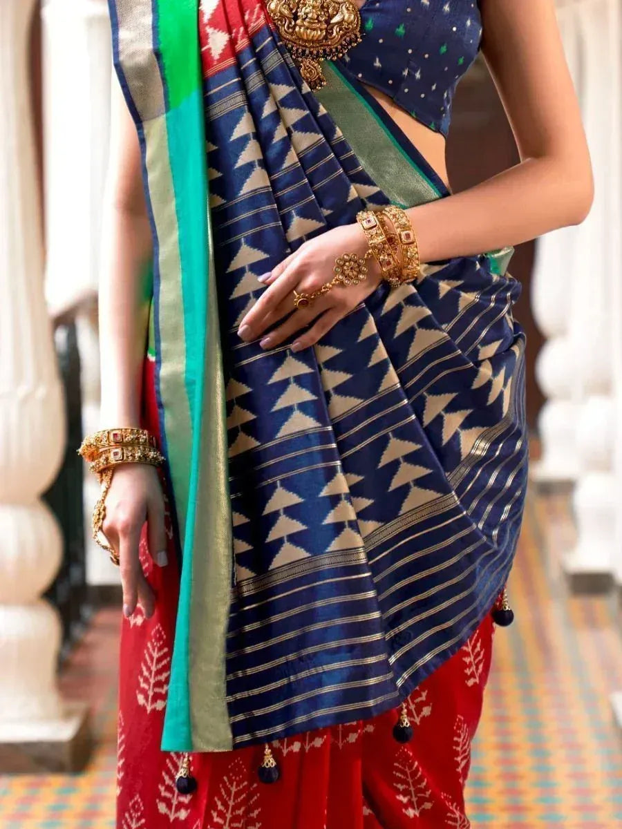 Blue and red ethnic saree with geometric print, gold jewelry, and designer blouse for Indian wear