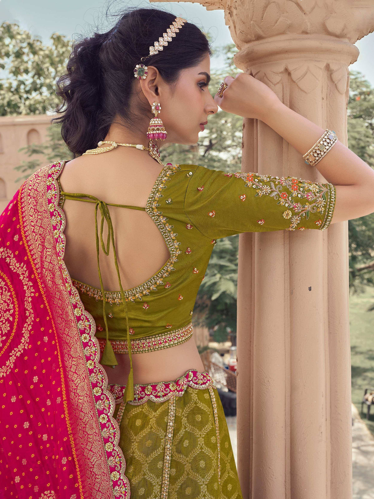 Olive green embroidered lehenga choli with pink dupatta, perfect for Indian weddings and festive occasions.