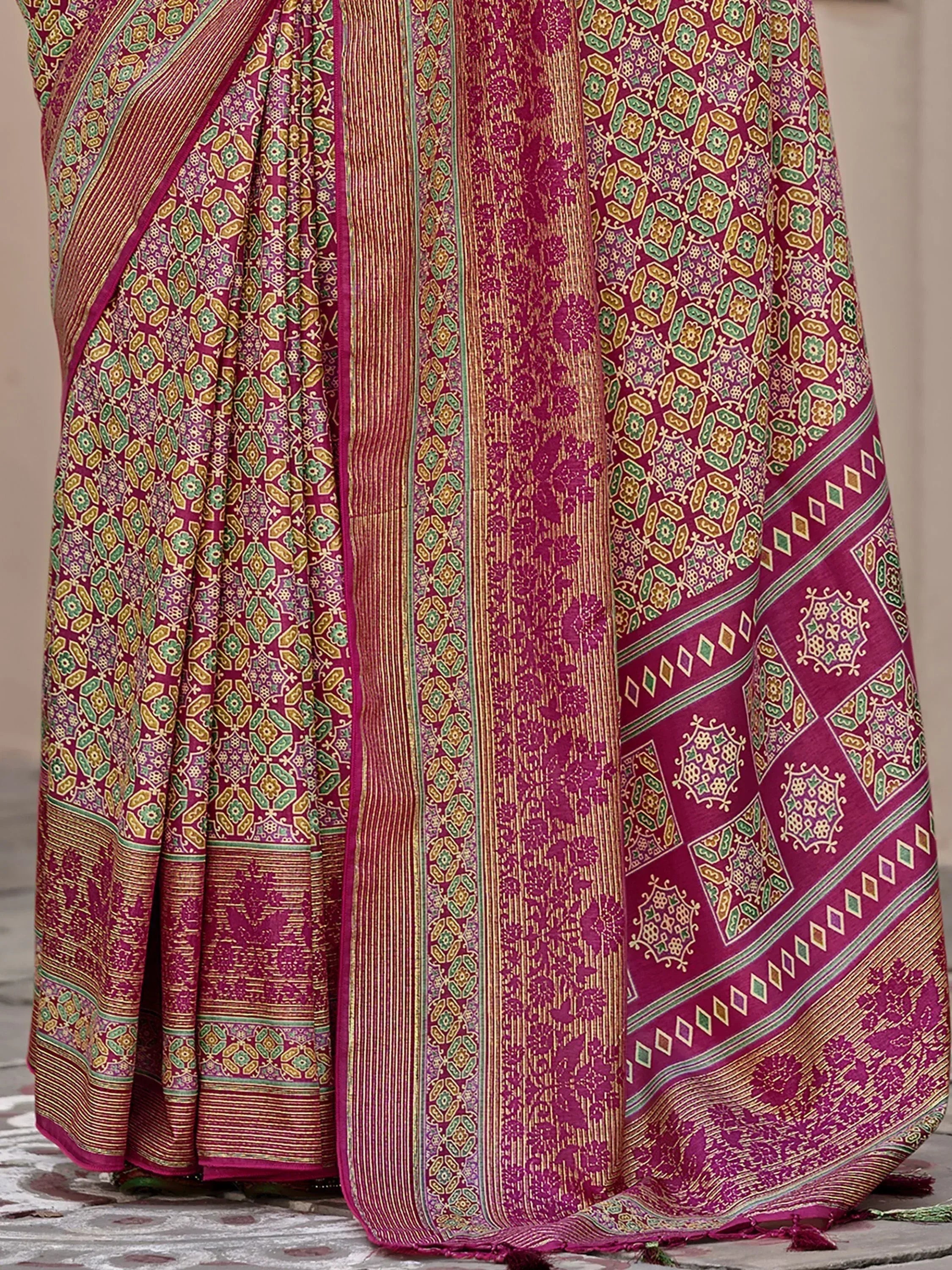 Rich magenta saree with intricate gold, green floral and geometric patterns, perfect for ethnic occasions.