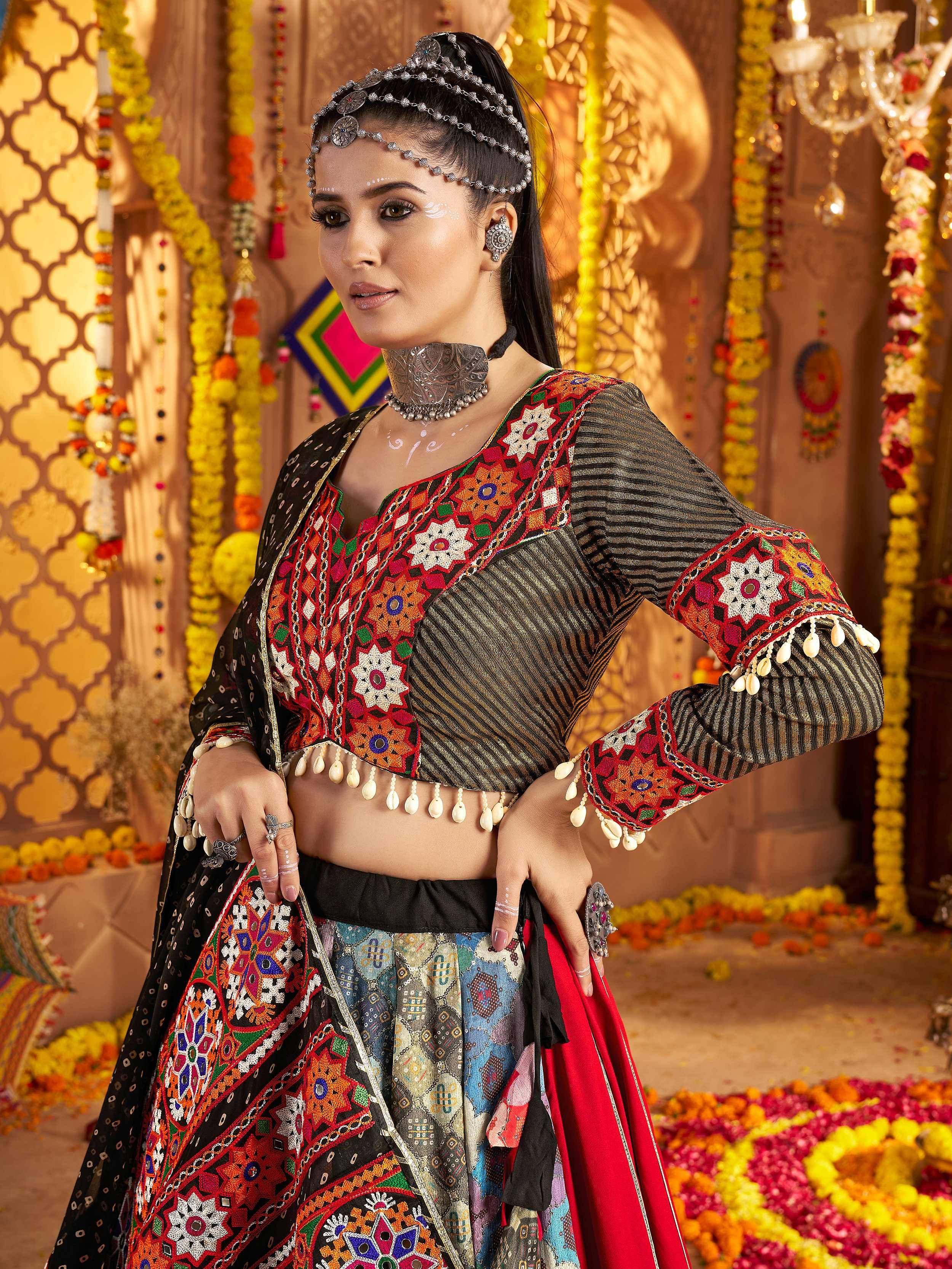 Woman in colorful embroidered ethnic lehenga choli with mirror work, traditional jewelry, and floral decor