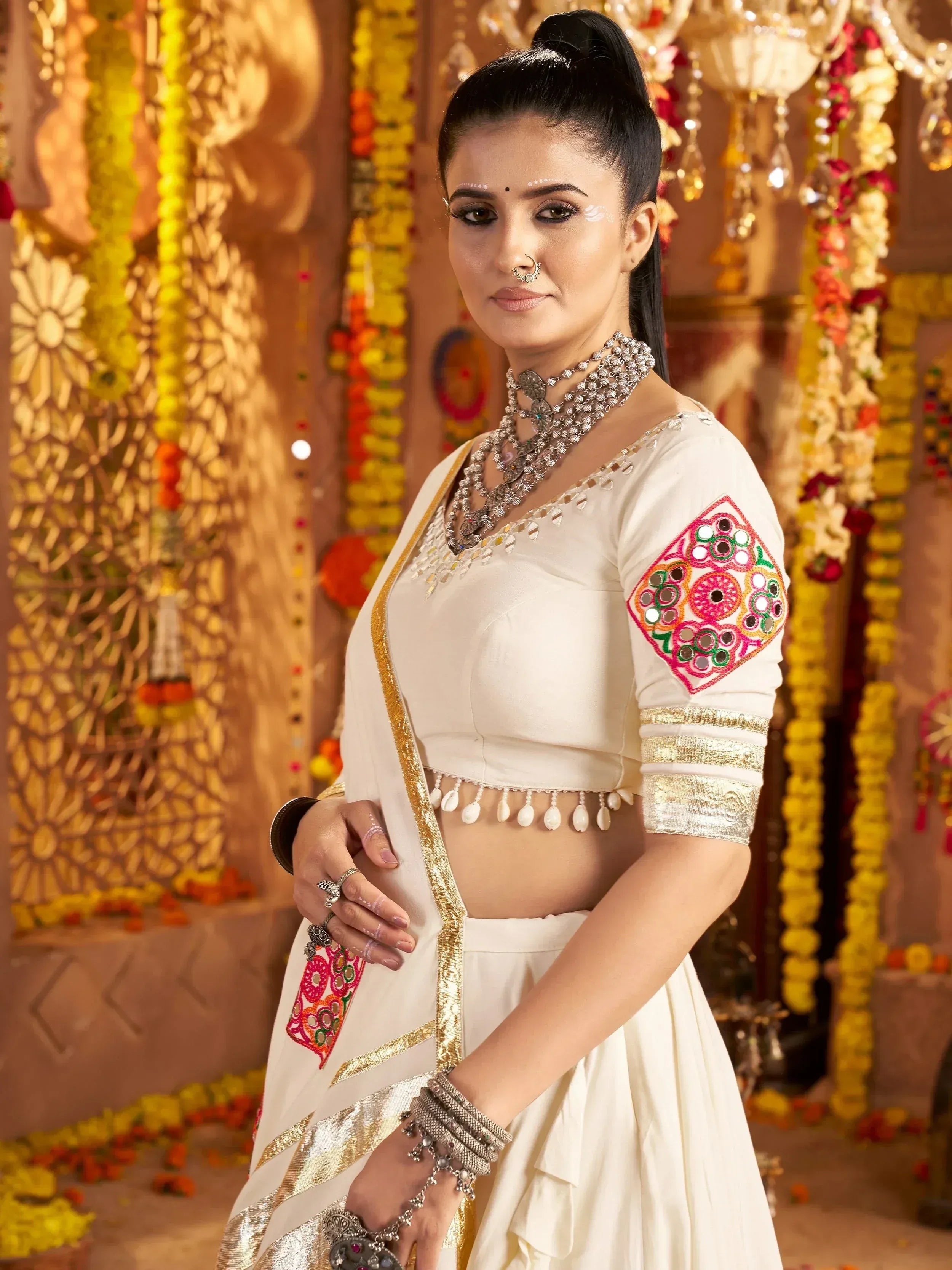 White ethnic lehenga choli with mirror work and gold trim, perfect for Indian weddings and festive occasions