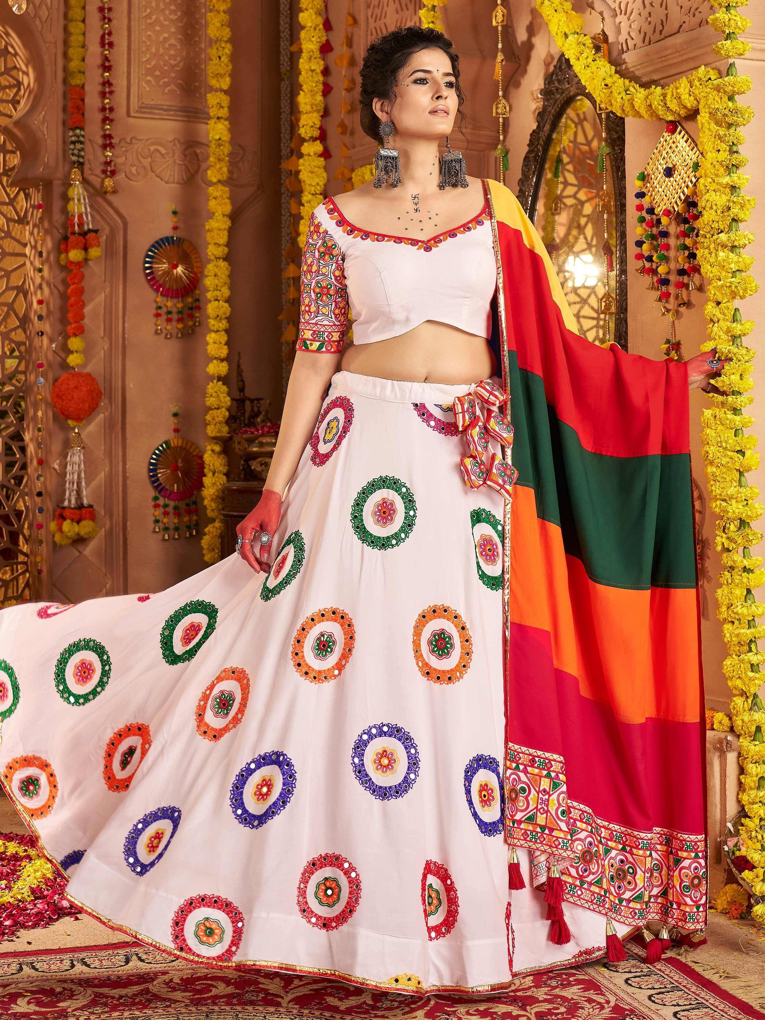 White embroidered lehenga choli with colorful mirror work and vibrant dupatta, perfect for Indian ethnic occasions.