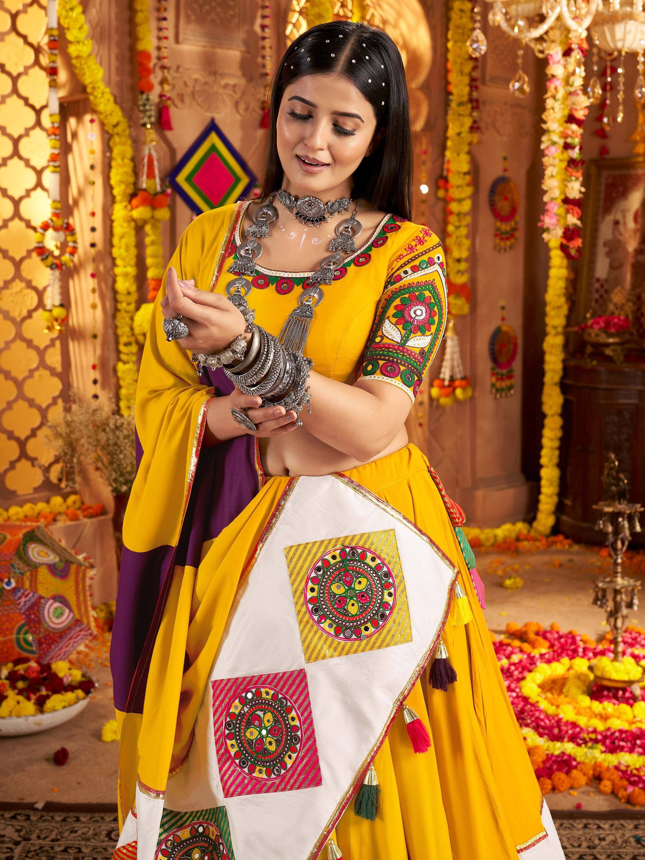 Yellow embroidered lehenga choli with mirror work, paired with silver jewelry and floral decor
