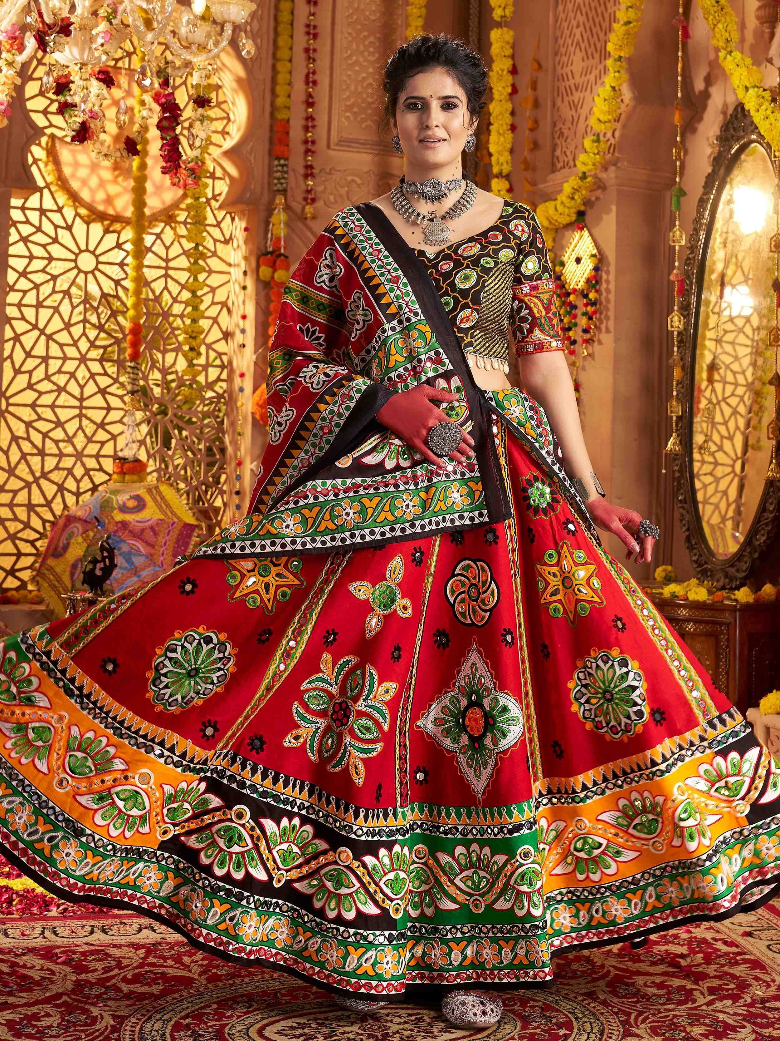 Vibrant red and green embroidered lehenga choli with mirror work, perfect for Indian ethnic occasions.