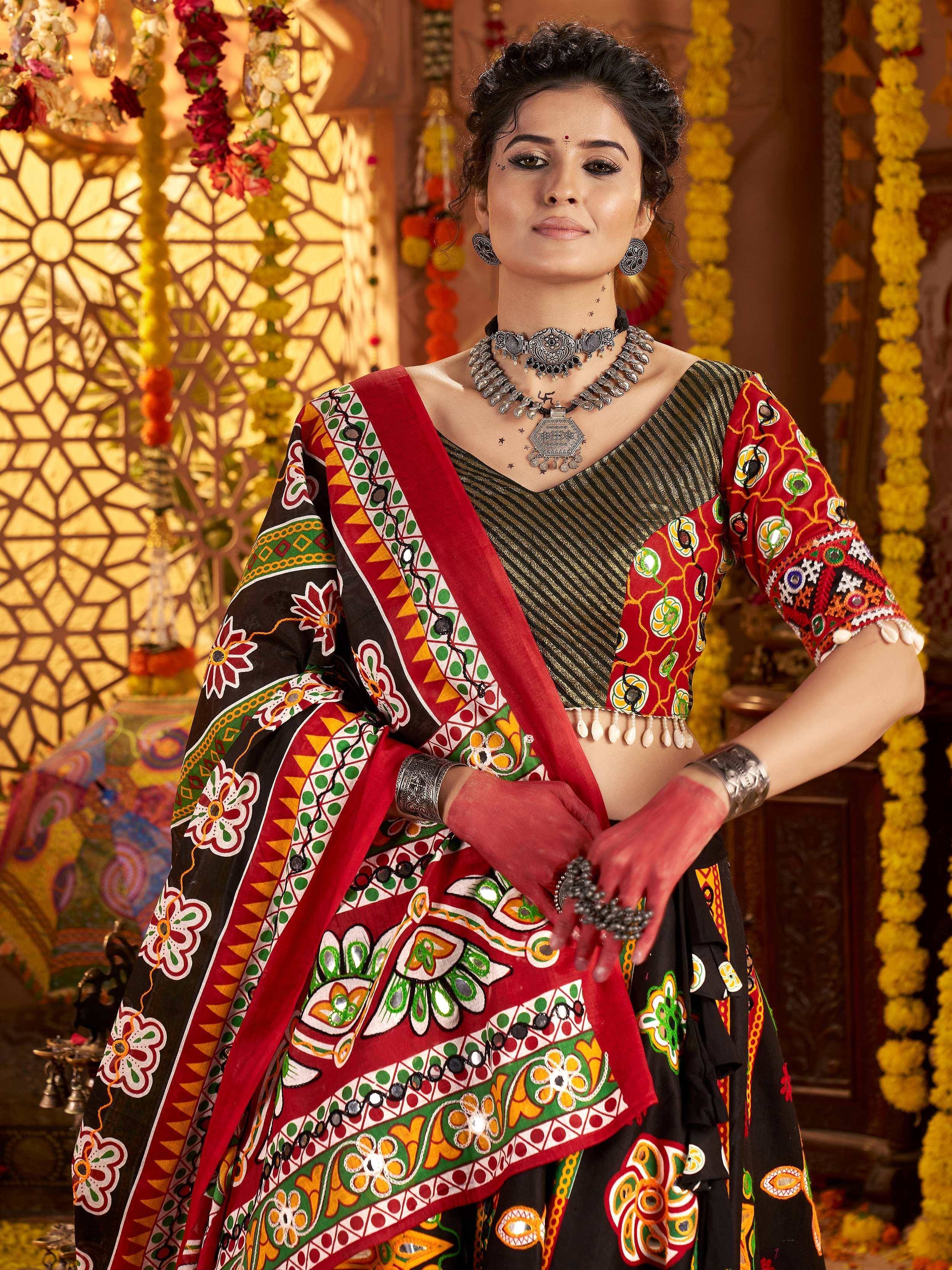 Woman in vibrant Indian ethnic wear with mirror work, floral patterns, and traditional jewelry, perfect for festive occasions.