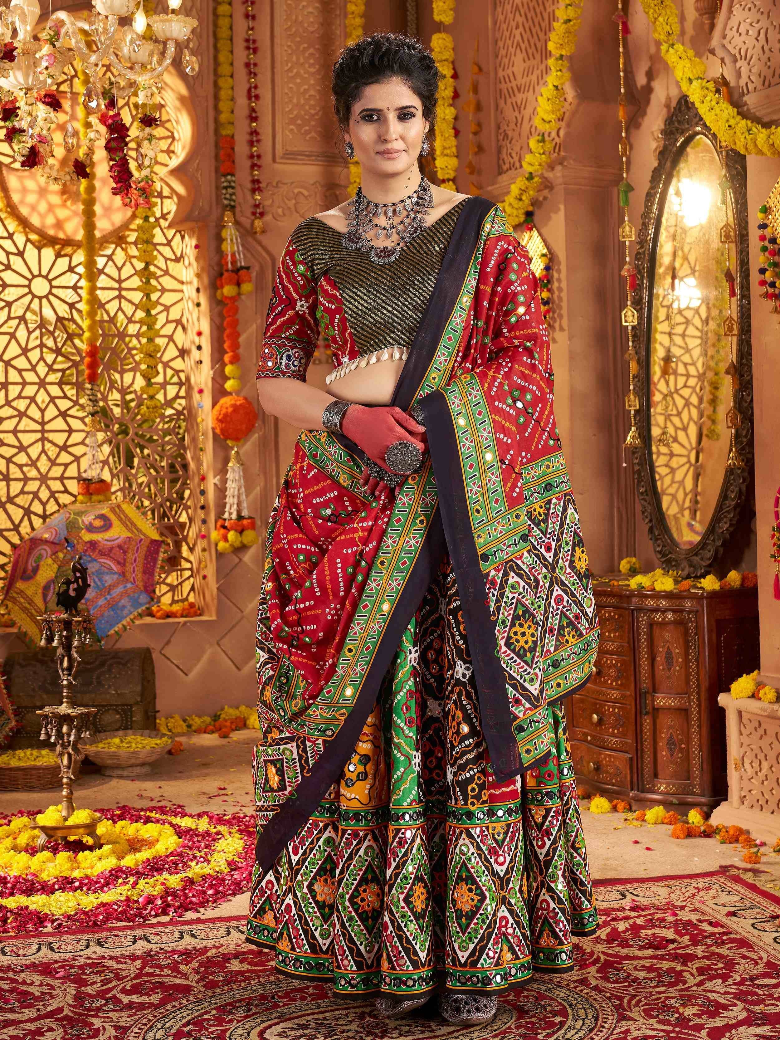 Woman in vibrant red and green printed lehenga choli with mirror work, traditional Indian ethnic wear