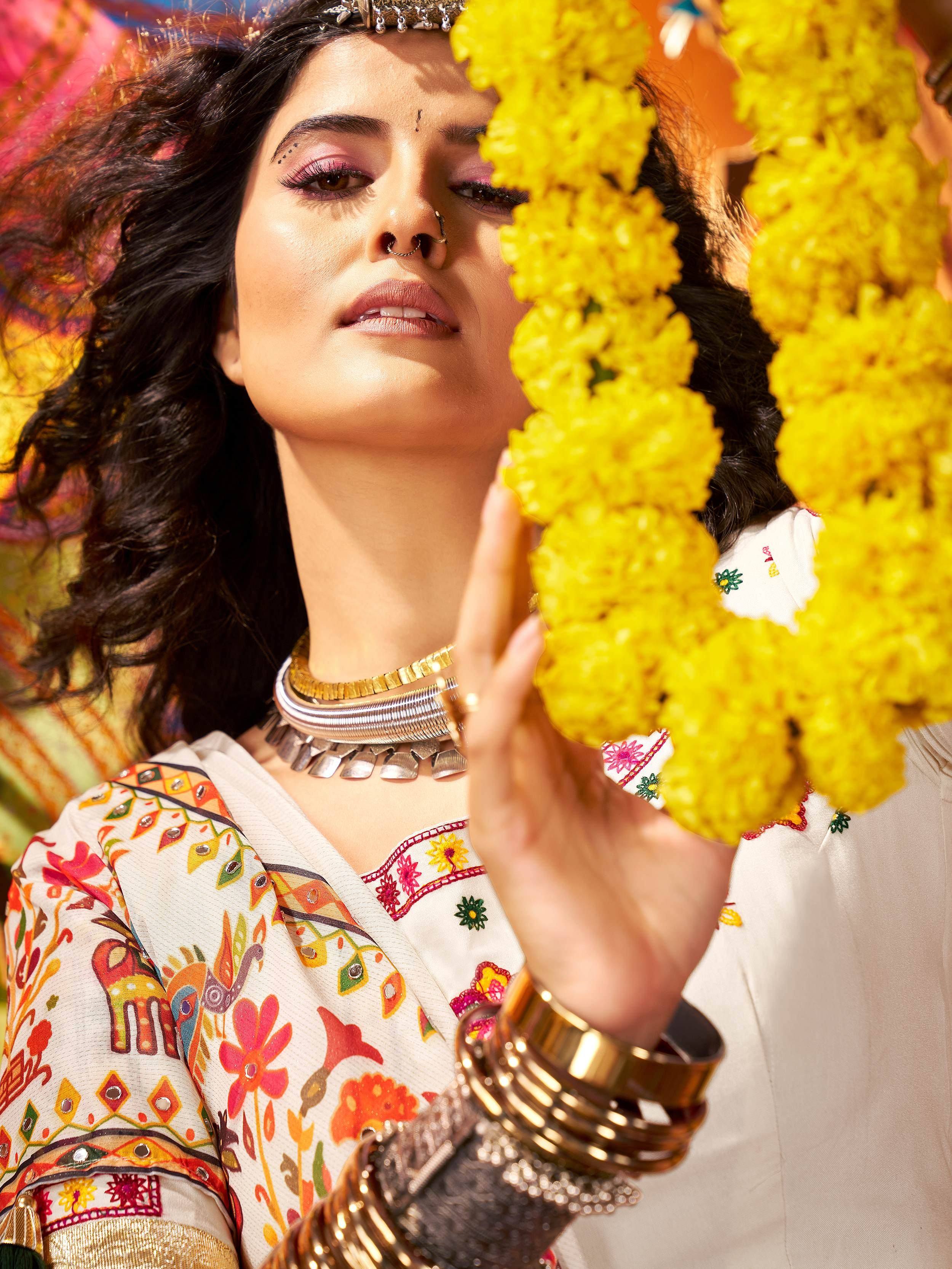 Woman in colorful embroidered Indian ethnic wear with floral garland and traditional jewelry
