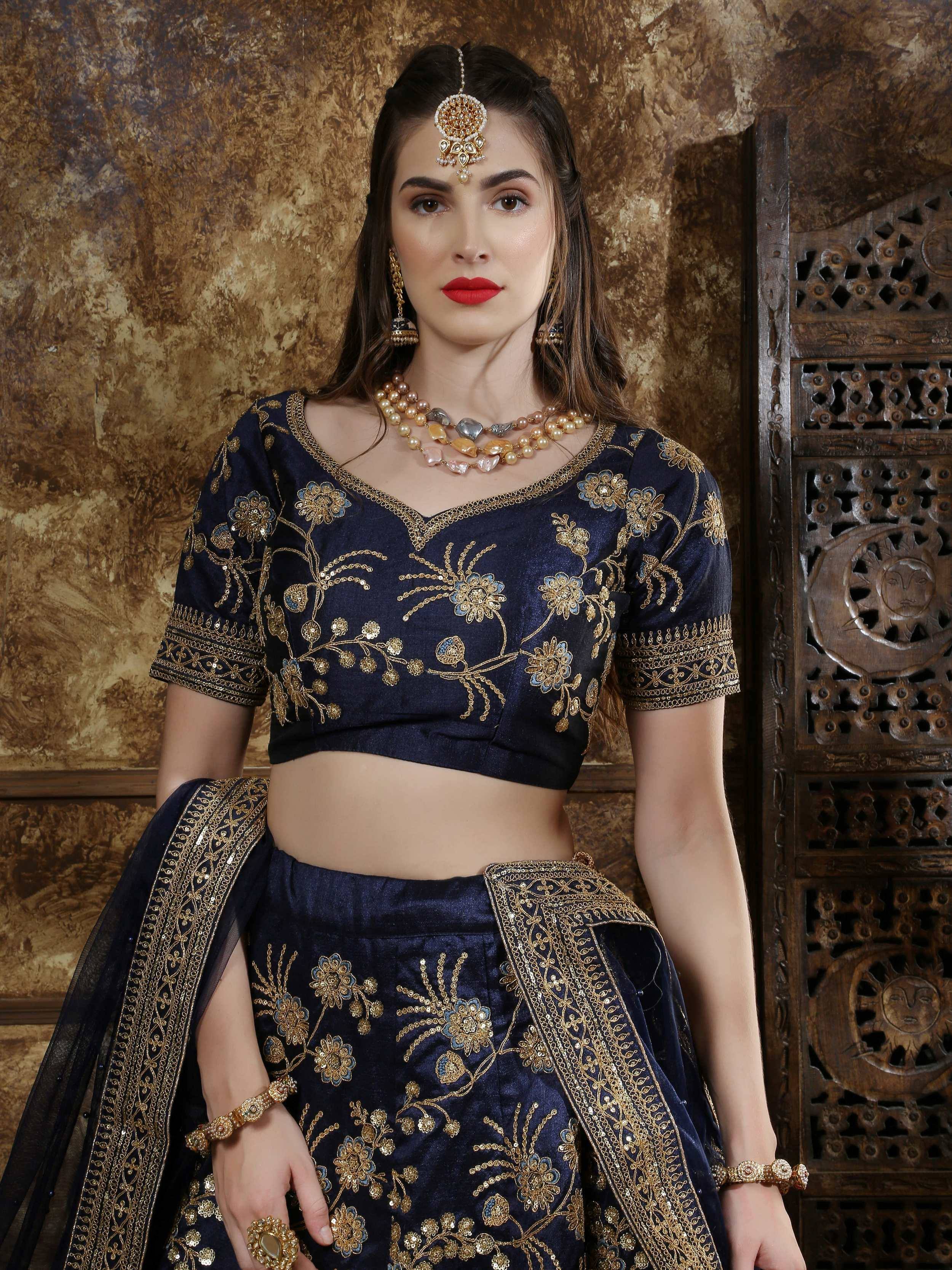 Navy blue embroidered lehenga choli with gold floral work, perfect for Indian weddings and festive occasions.