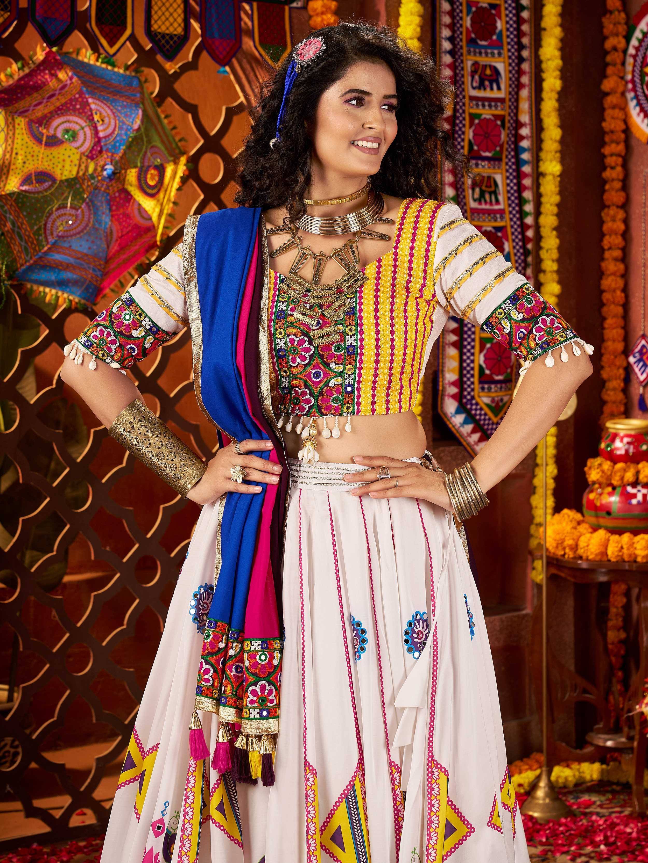 Colorful embroidered Indian lehenga choli with mirror work, paired with blue dupatta and traditional jewelry