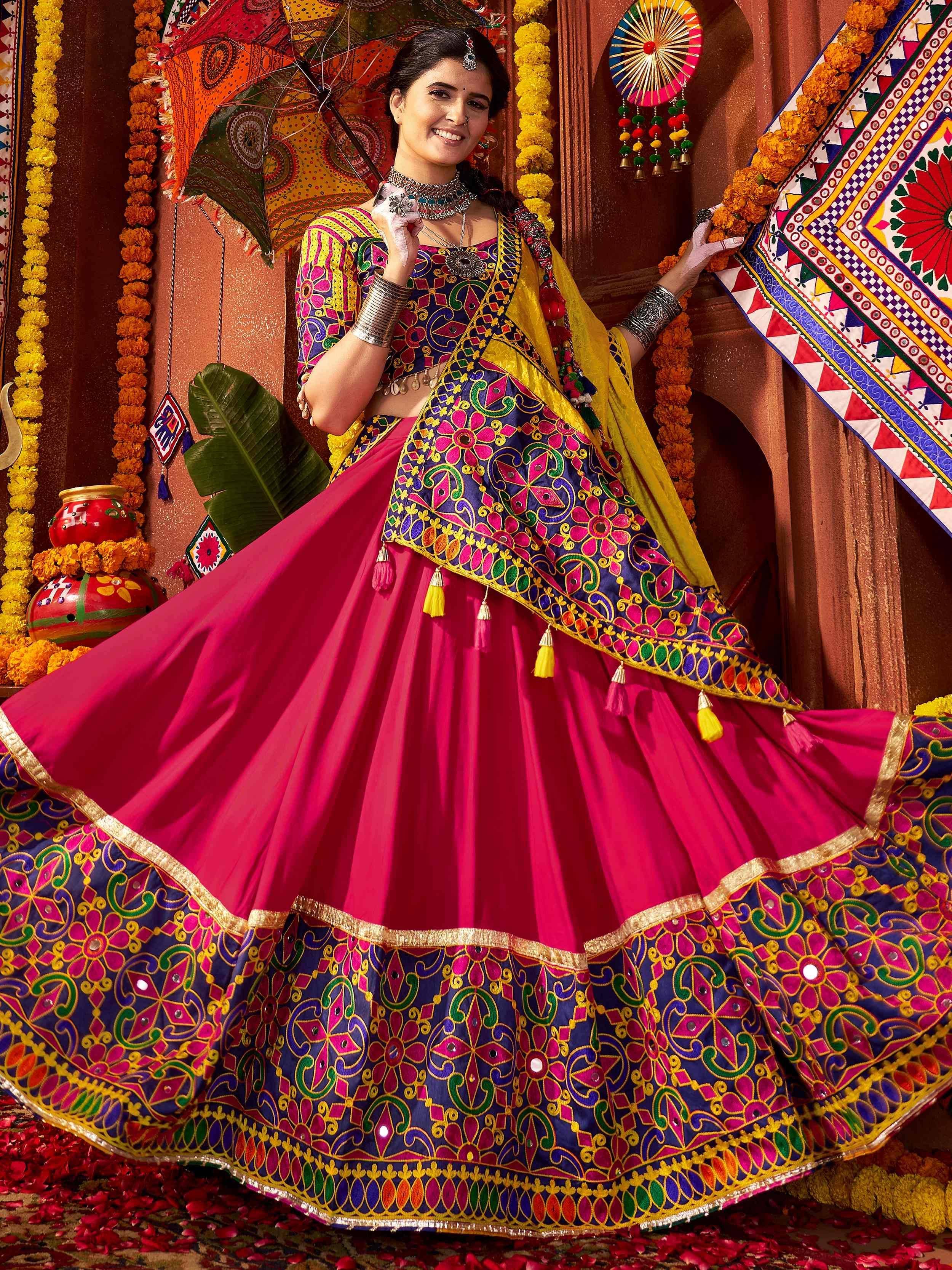 Vibrant pink and blue embroidered lehenga choli with mirror work, perfect for Indian ethnic wear and festive occasions.