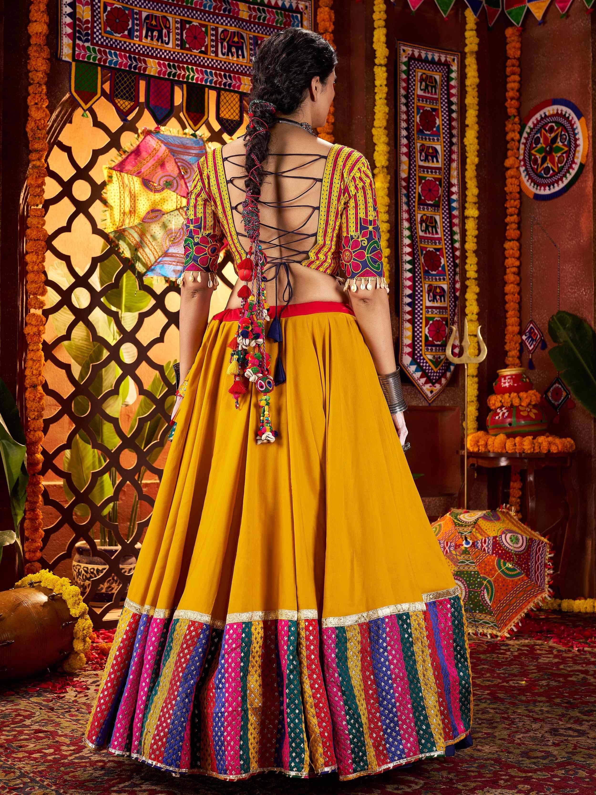 Vibrant yellow lehenga choli with colorful embroidery, back tie-up blouse, and festive Indian decor
