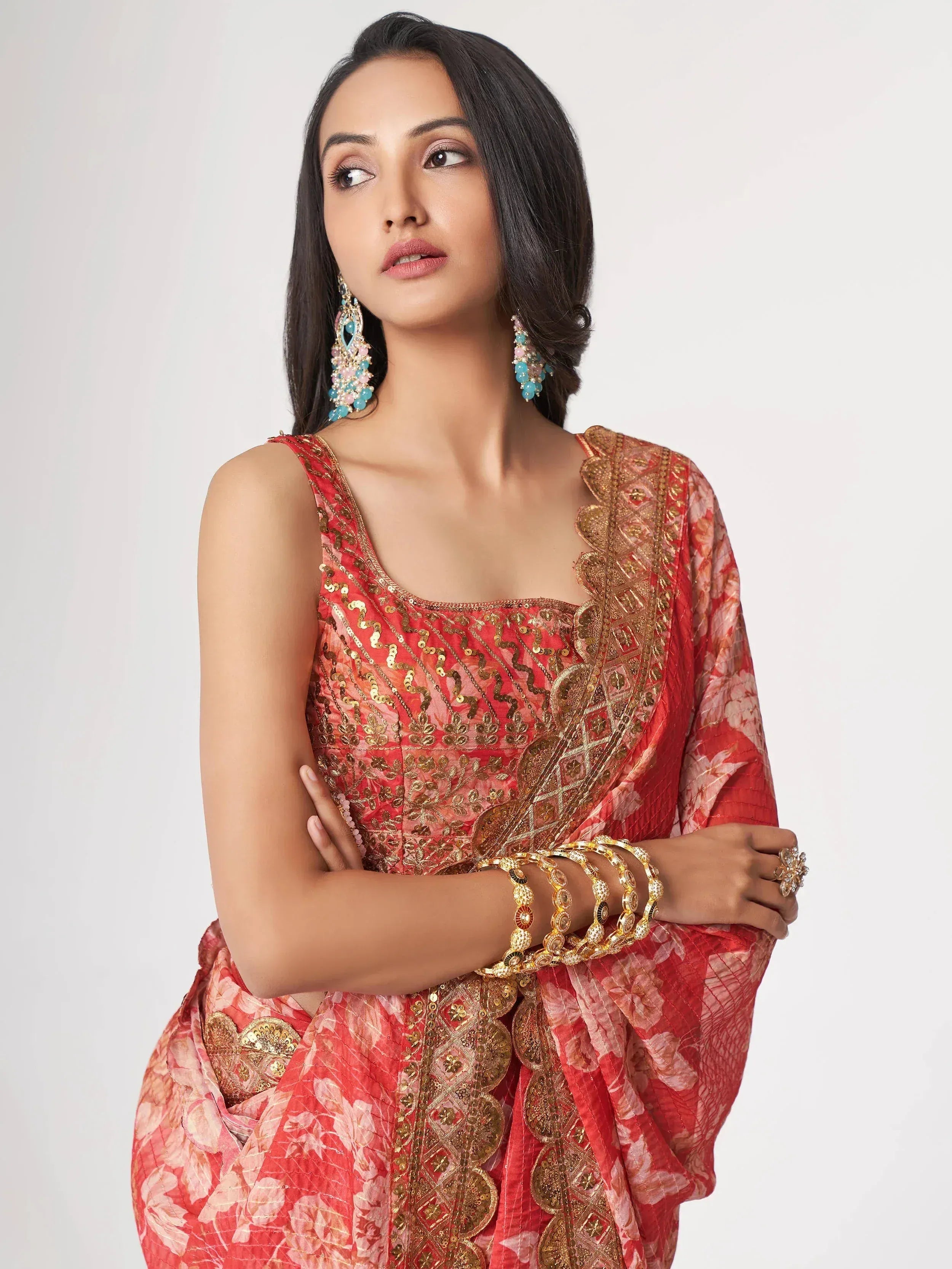 Woman in red floral ethnic gown with gold embroidery and statement jewelry