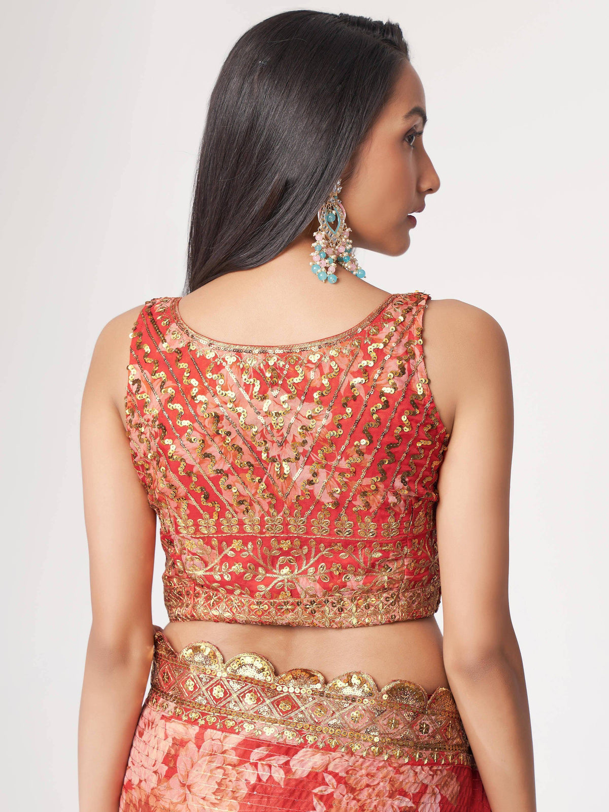 Red and gold sequined lehenga choli with floral print and scalloped waist, paired with statement earrings