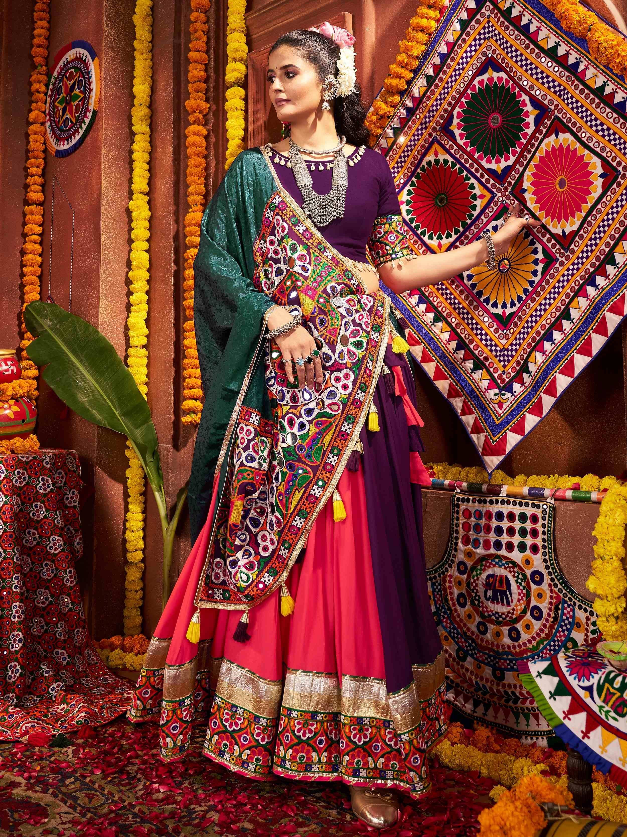 Woman in vibrant Indian ethnic wear with mirror work, floral garlands, and traditional decor