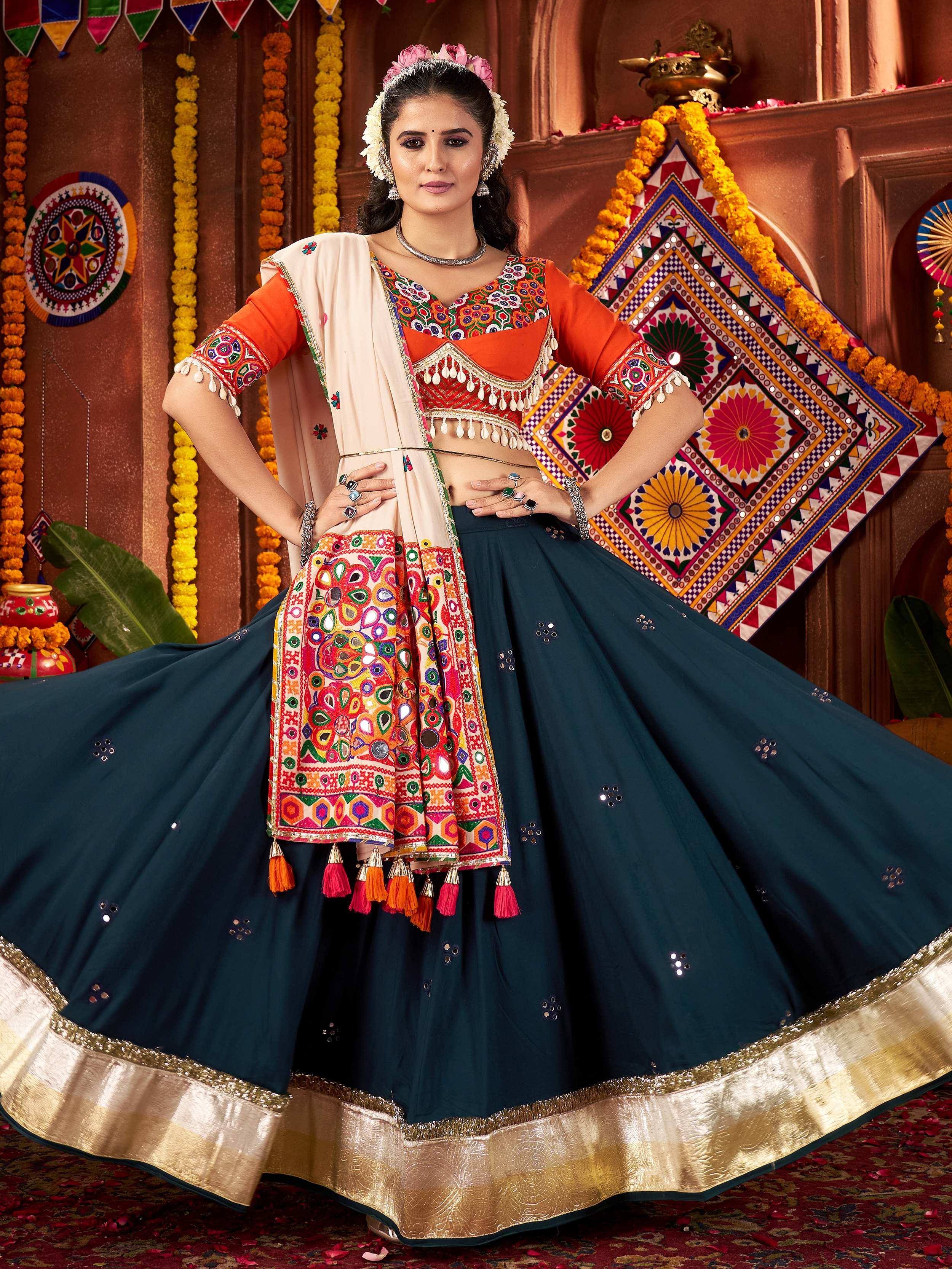 Vibrant Indian ethnic lehenga choli with mirror work, tassels, and gold border for festive occasions