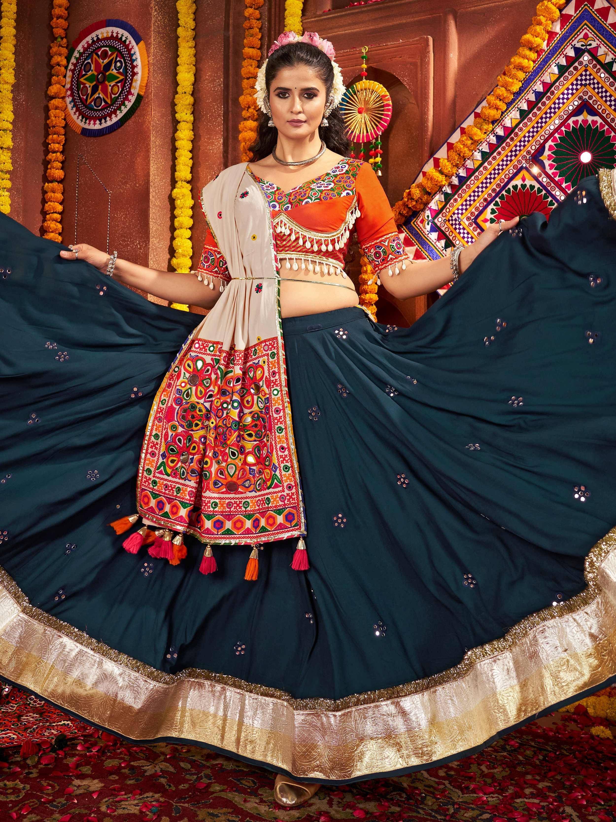Vibrant Indian ethnic lehenga choli with mirror work, tassels, and gold border, perfect for festive occasions.