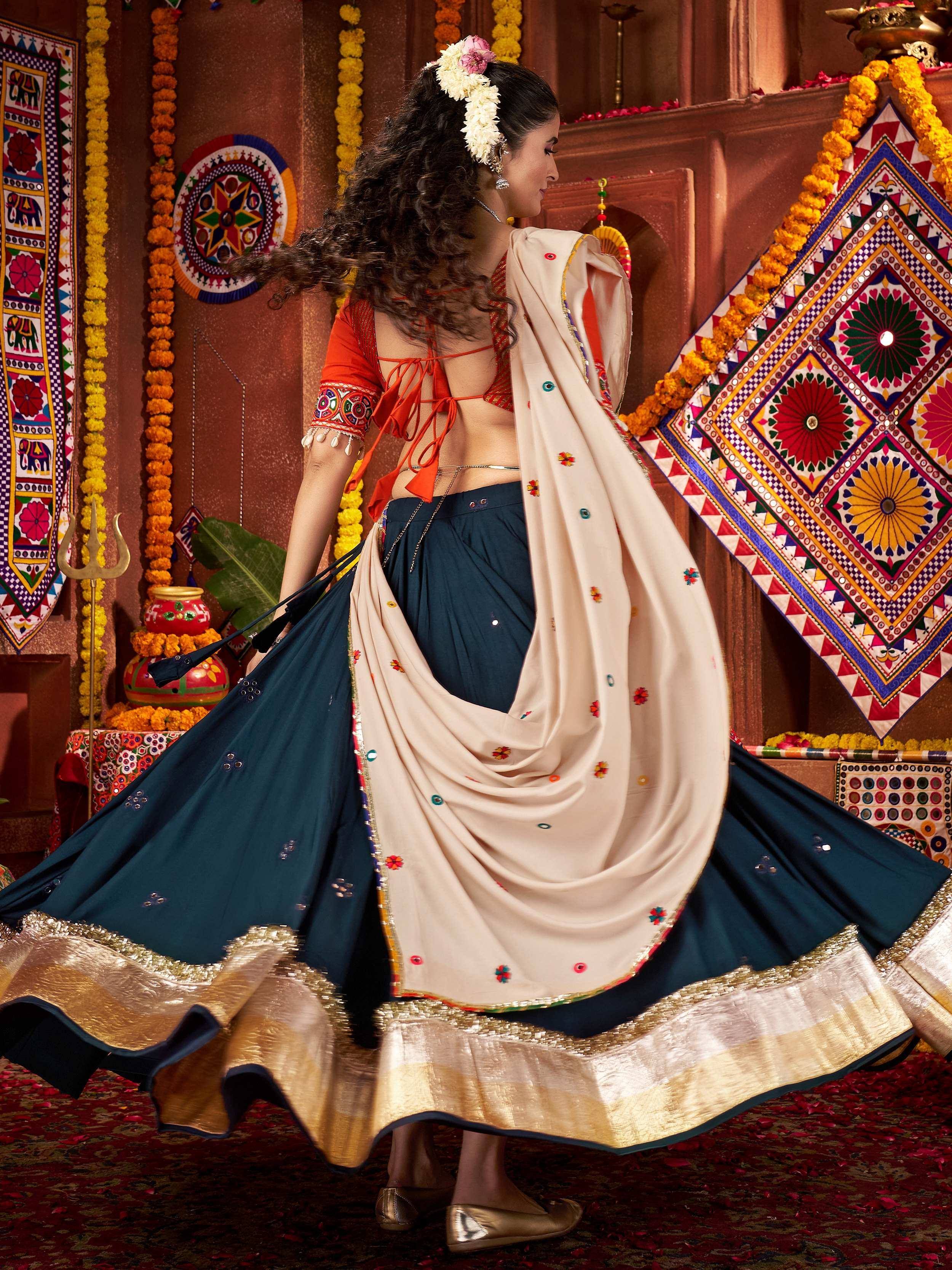 Elegant Indian ethnic wear with navy blue lehenga, floral dupatta, and vibrant decor