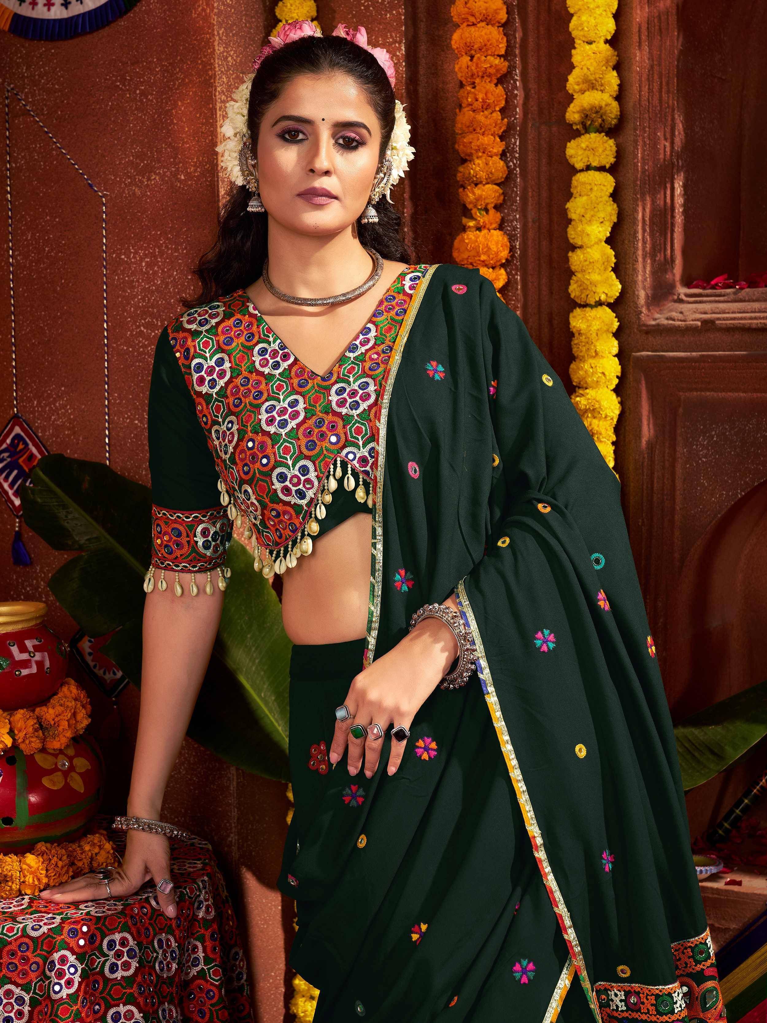 Green embroidered ethnic saree with floral motifs and mirror work, perfect for festive occasions