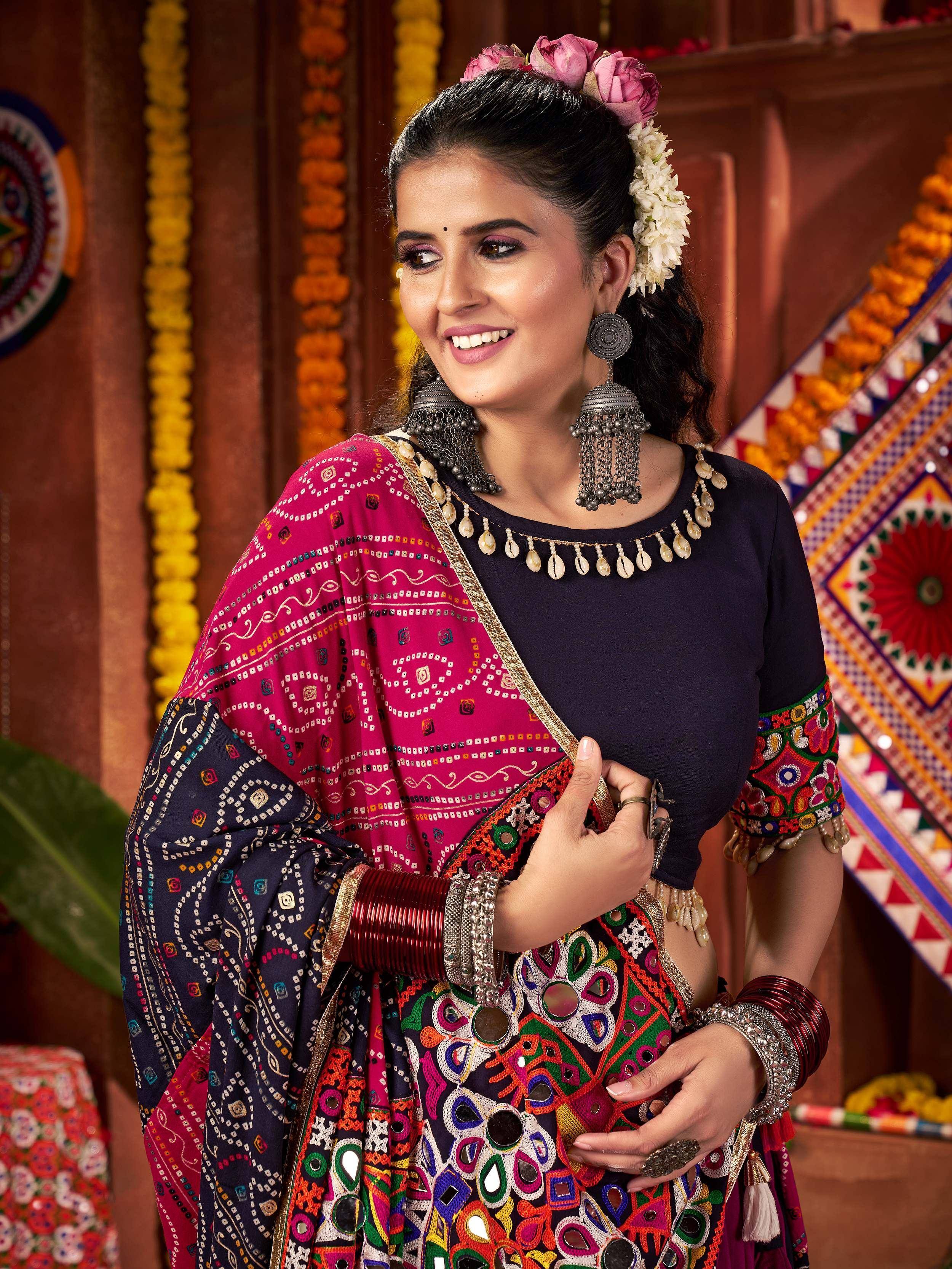 Woman in vibrant ethnic Indian attire with mirror work and floral hair accessories