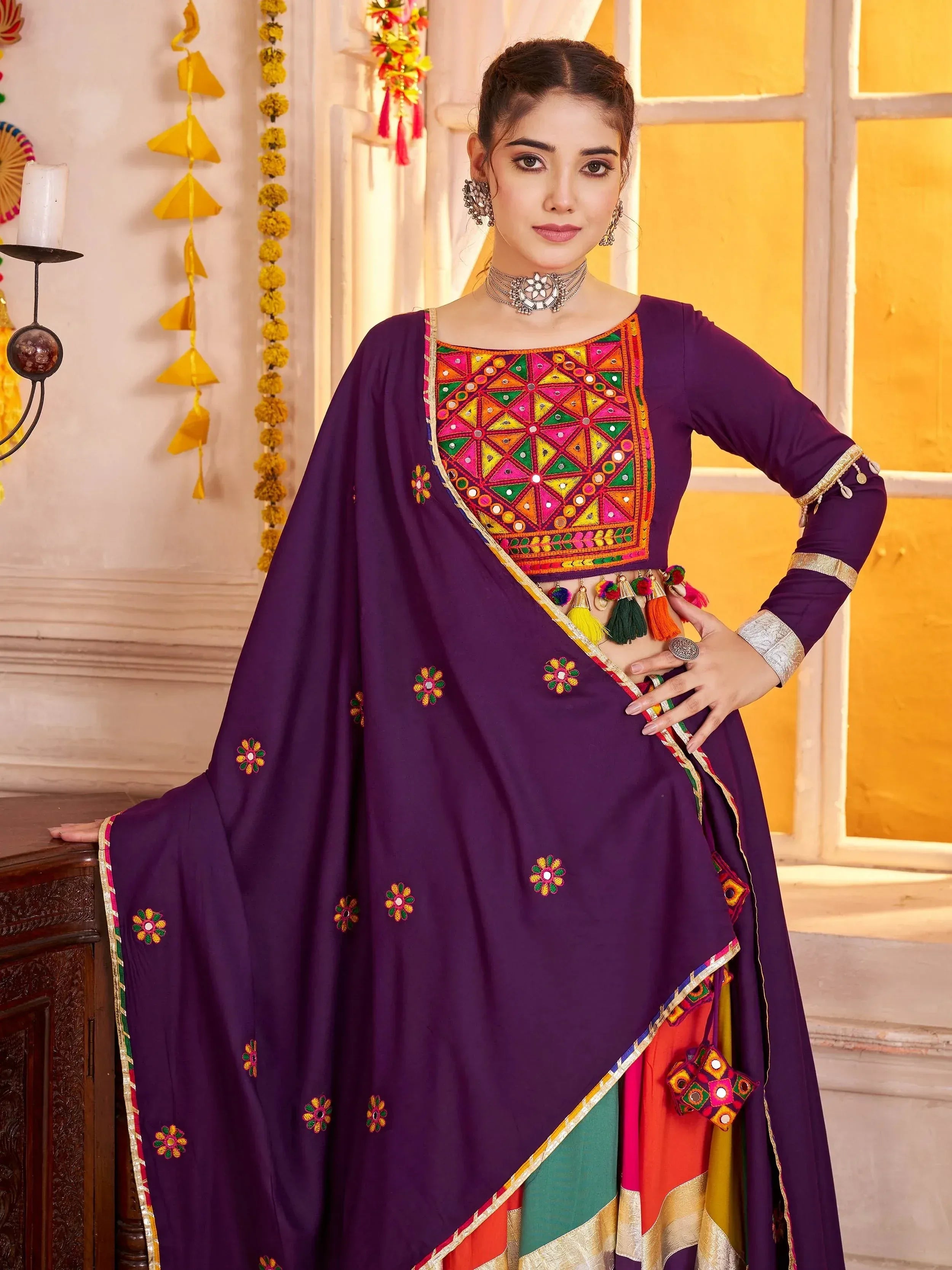 Purple ethnic wear with mirror work and tassels, perfect for festive occasions