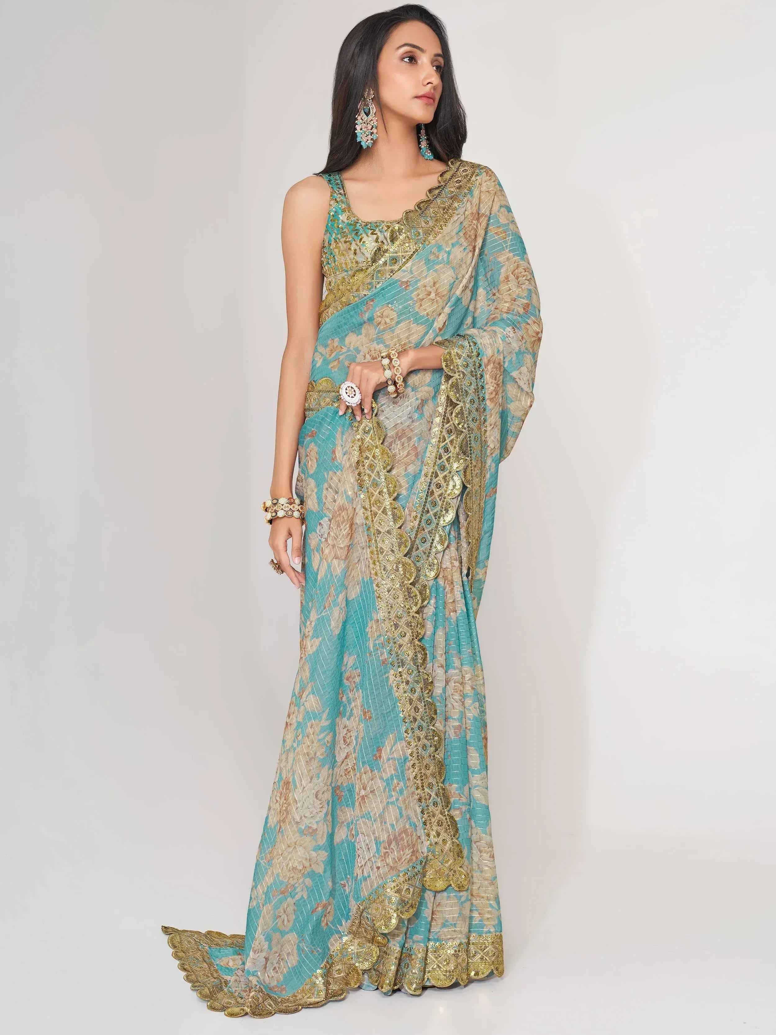 Elegant turquoise and gold floral saree with intricate embroidery and sequin work, perfect for Indian ethnic occasions.