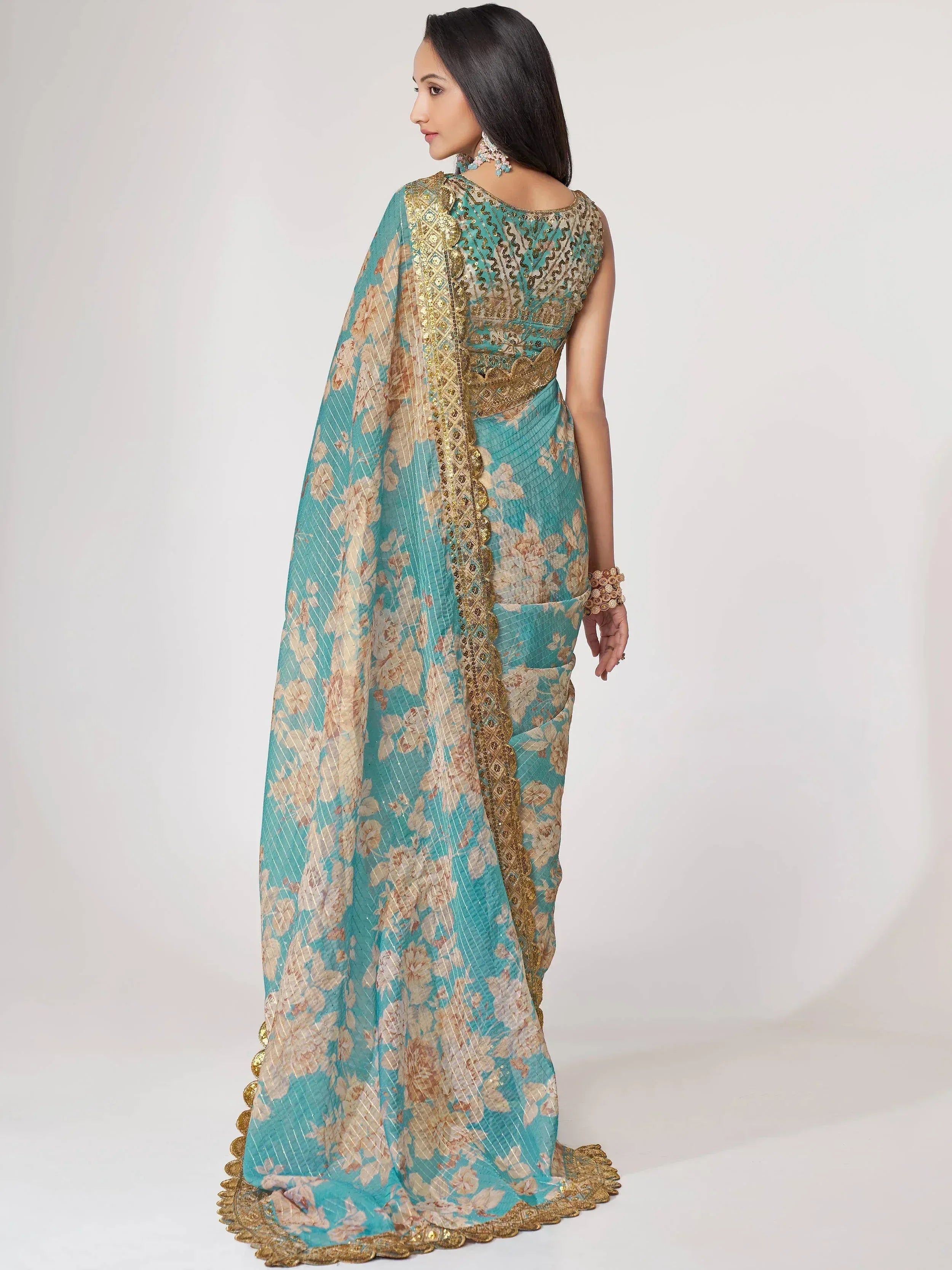 Teal floral saree with gold embroidery, perfect for Indian ethnic wear and designer occasions.