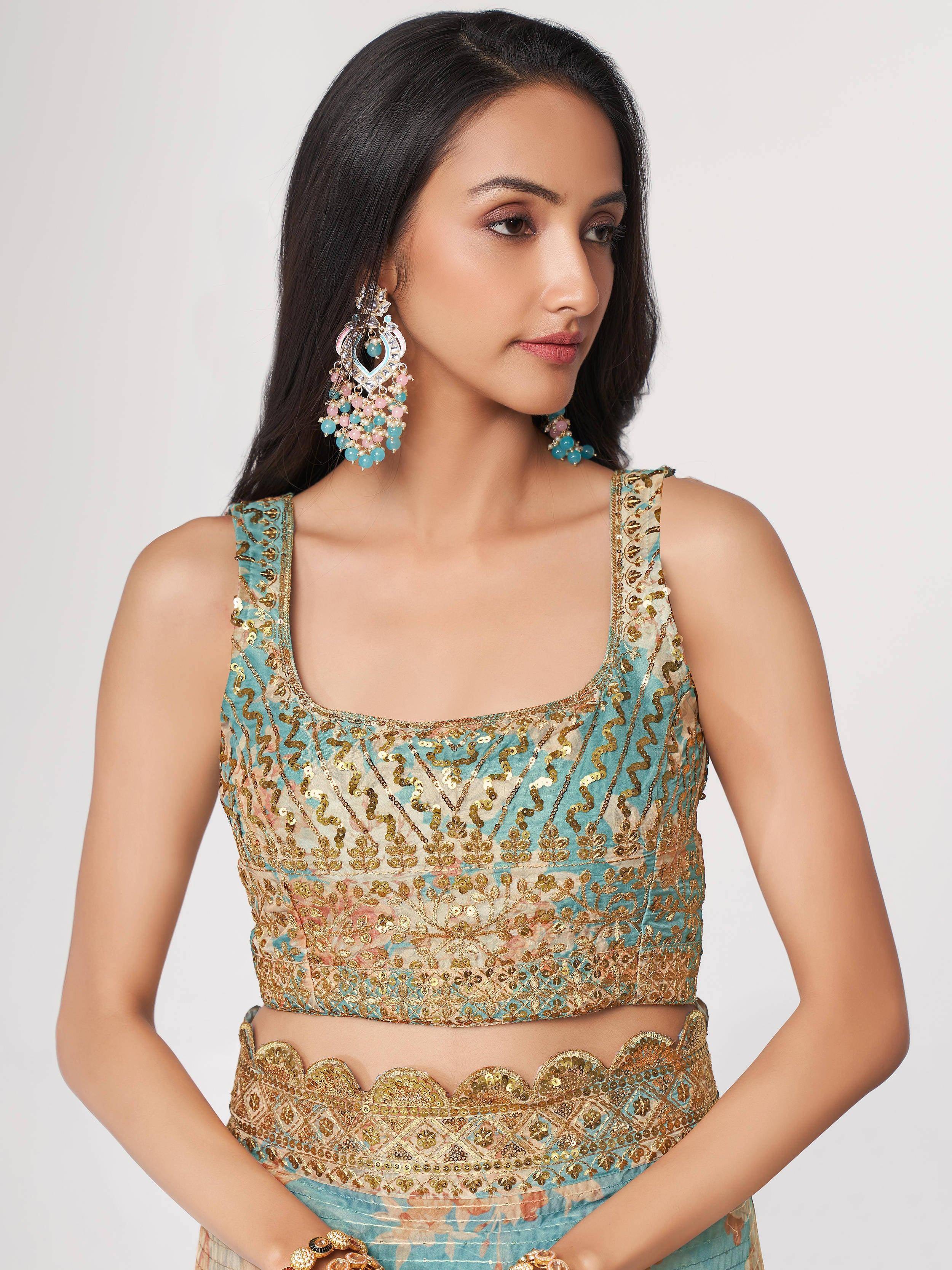 Turquoise and gold embroidered lehenga choli with matching statement earrings, perfect for Indian ethnic wear.