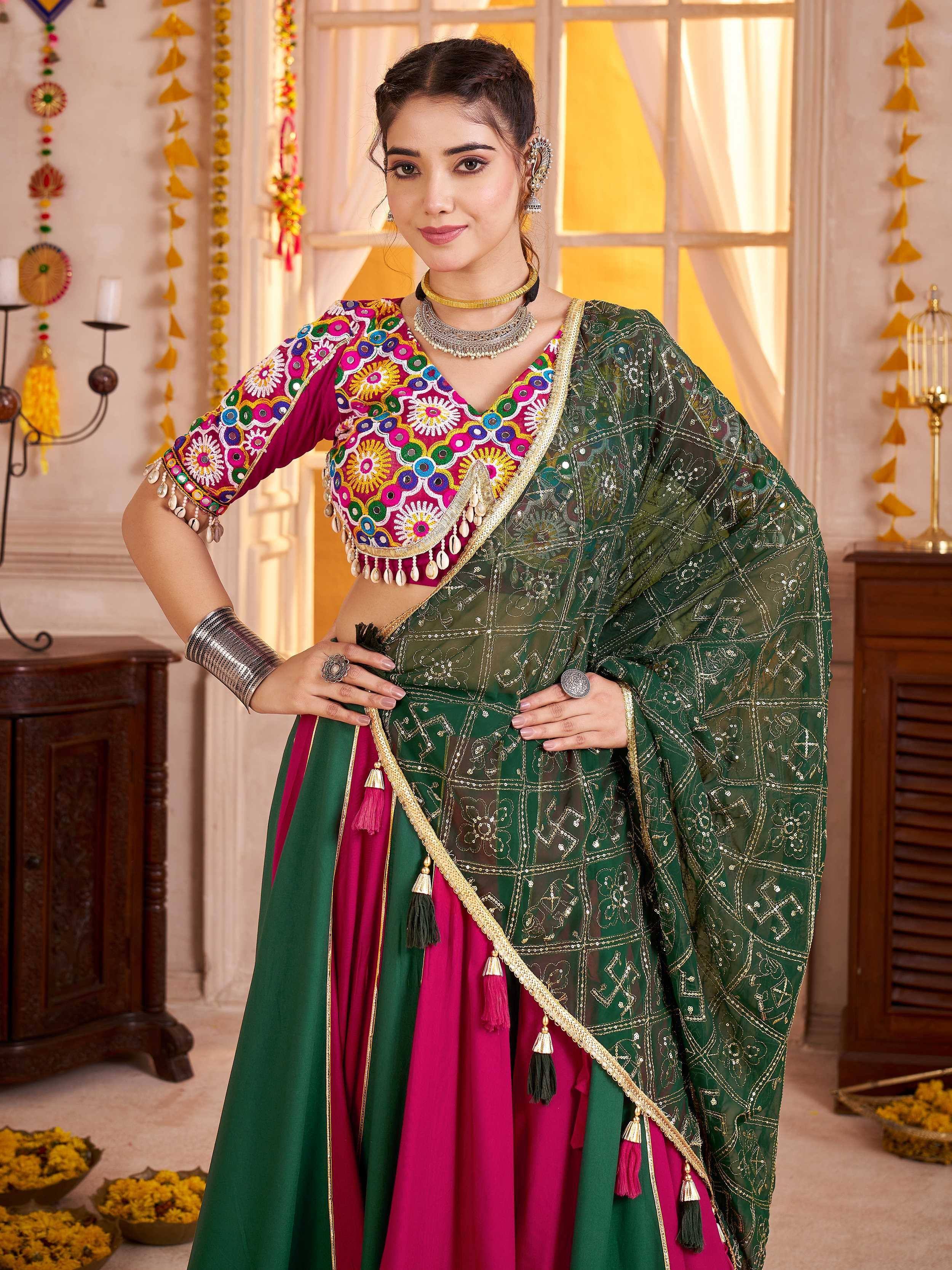 Woman in vibrant green and pink embroidered lehenga choli with mirror work, perfect for Indian ethnic occasions.
