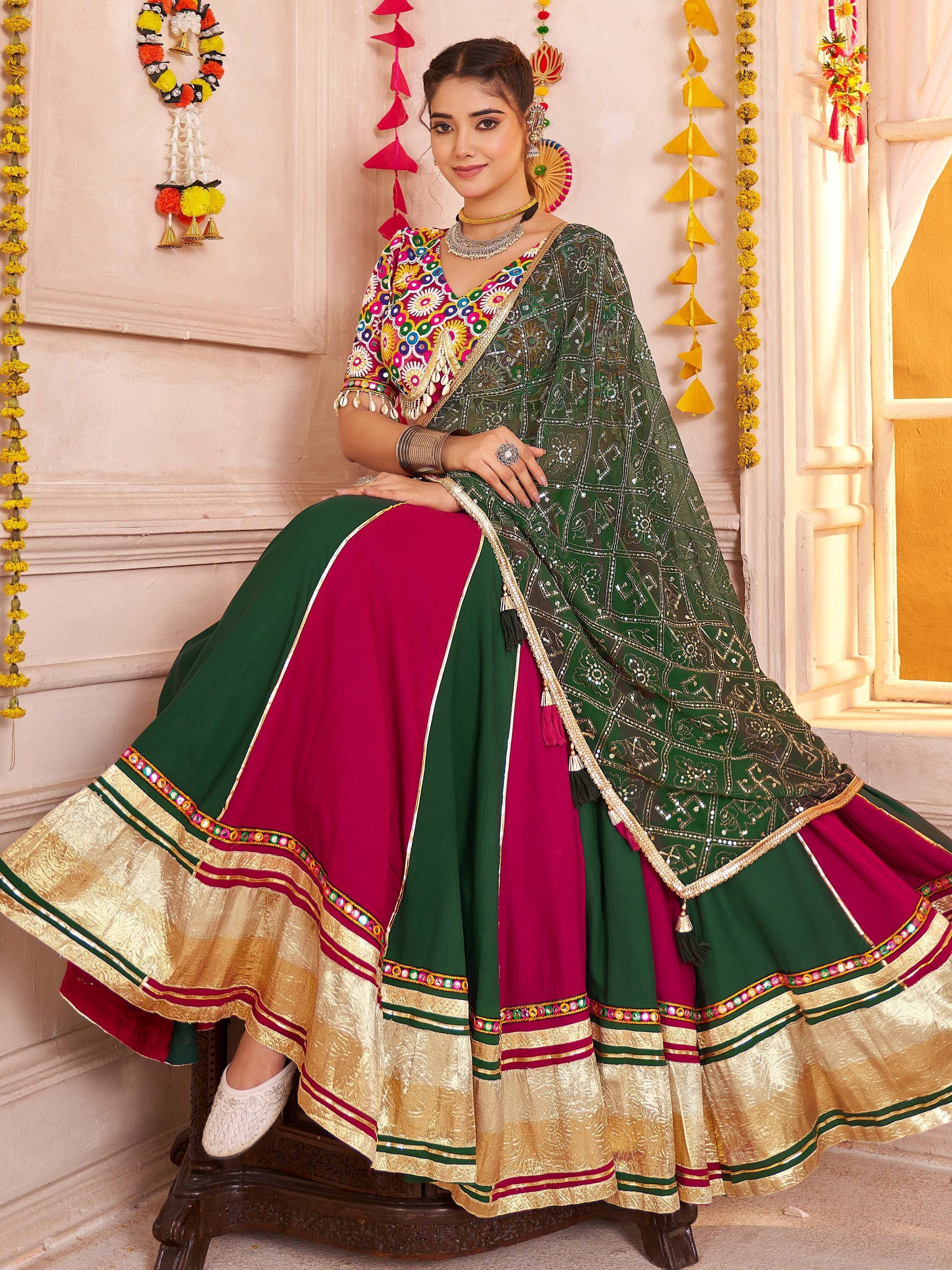 Woman in vibrant green and maroon embroidered lehenga choli with gold border, perfect for Indian ethnic occasions.