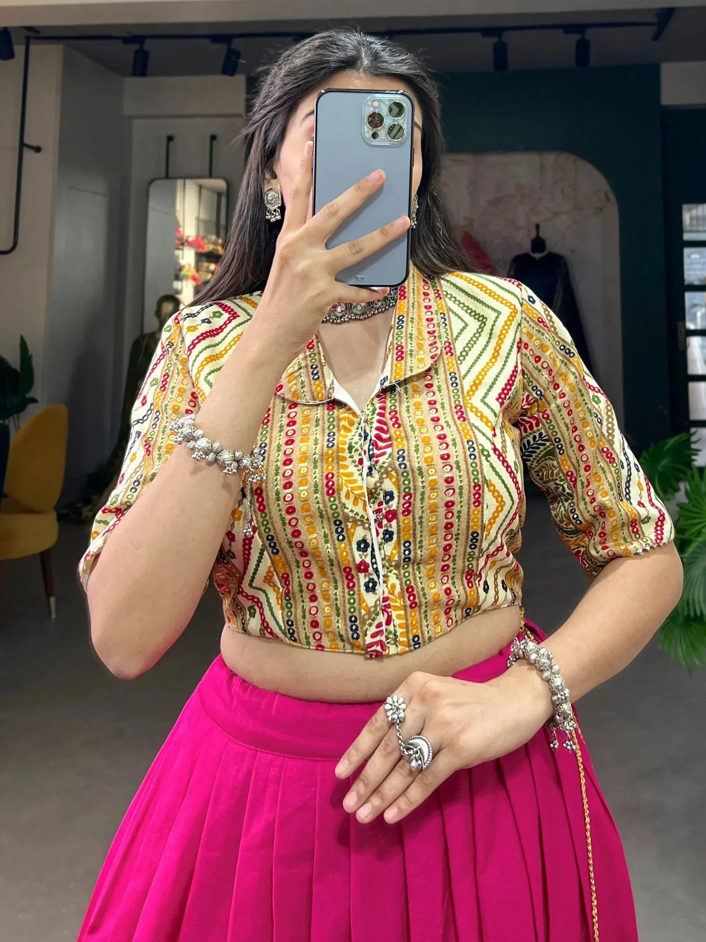 Woman in colorful embroidered crop top and pink pleated skirt, Indian ethnic wear