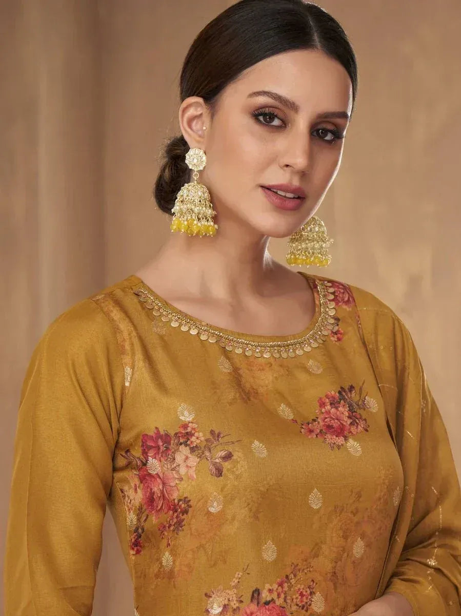 Woman in mustard floral ethnic gown with statement earrings, traditional Indian wear